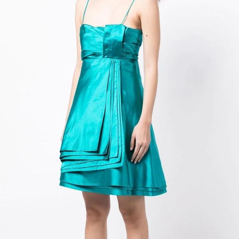 Crafted in Italy from the finest silk in turquoise, this elegant mini dress by Prada is the kind you rely on when you get an invitation to a party. Cut with an effortlessly light yet layered silhouette, this glamorous piece features an