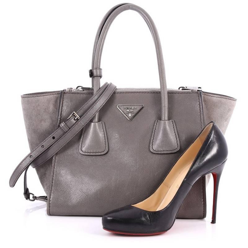 This authentic Prada Twin Pocket Tote Glace Calf Small showcases a sophisticated silhouette balancing modern luxury and style perfect for the on-the-go woman. Crafted from grey glace calf leather, this boxy tote features tall dual-rolled top