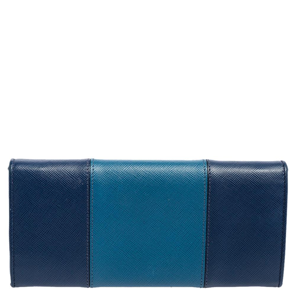 This Continental wallet is from Prada. It has been crafted from two-tone blue gold Saffiano Lux leather and equipped with a flap leading to multiple slots and a zip pocket for you to neatly carry your essentials.