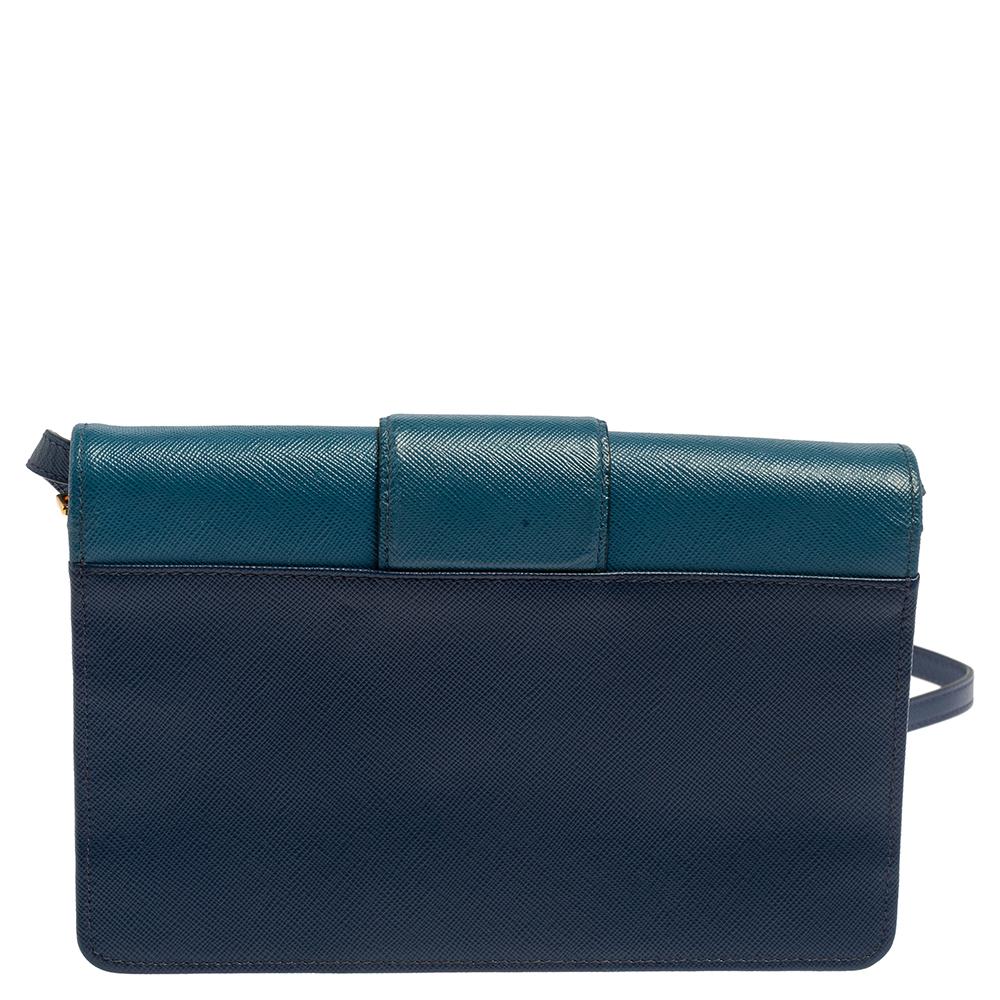 Trade that everyday tote with this charming crossbody bag from the house of Prada. It features a two-toned blue leather body, an adjustable shoulder strap, and the logo in gold-tone on the front. The interior can hold your daily essentials with