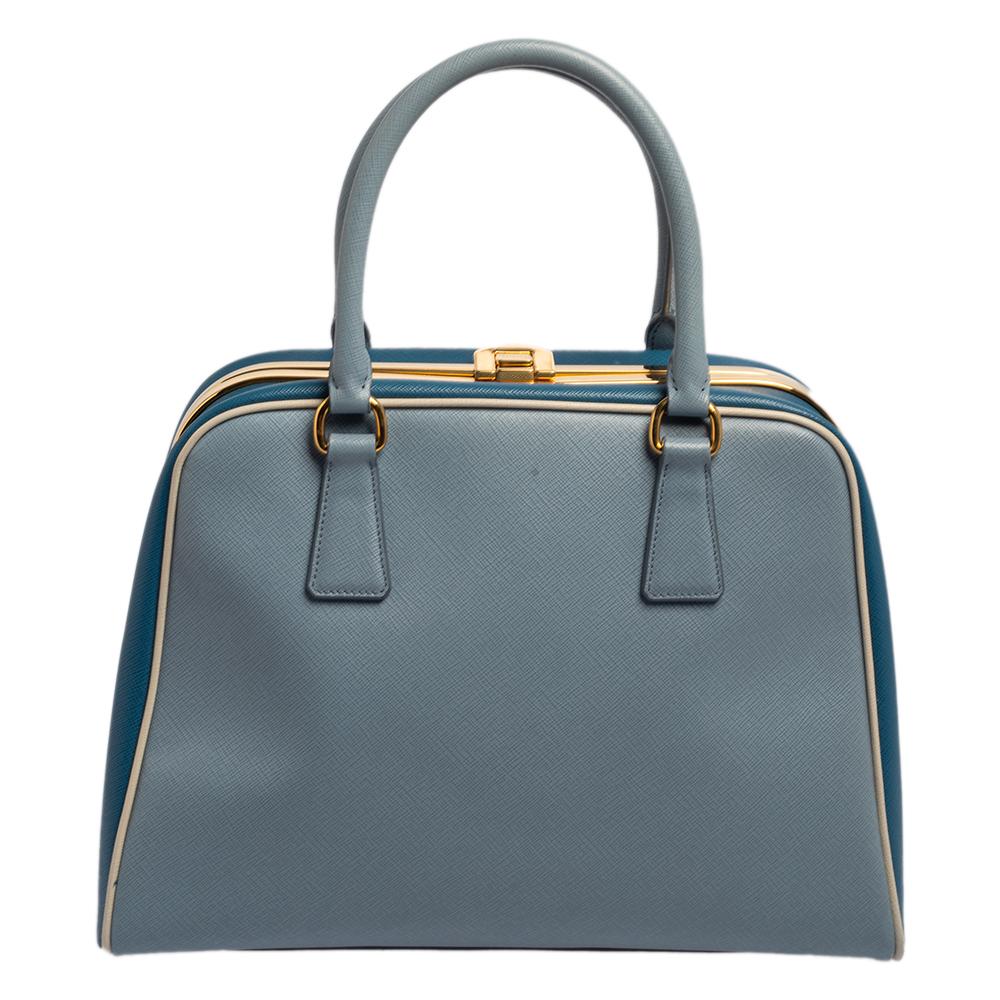 Dando a los bolsos de asa una actualización elegante, este bolso Pyramid Frame de Prada será una valiosa incorporación a tu armario. Está confeccionado en piel Saffiano Lux y adornado con herrajes dorados. Viene con dos asas superiores, pies