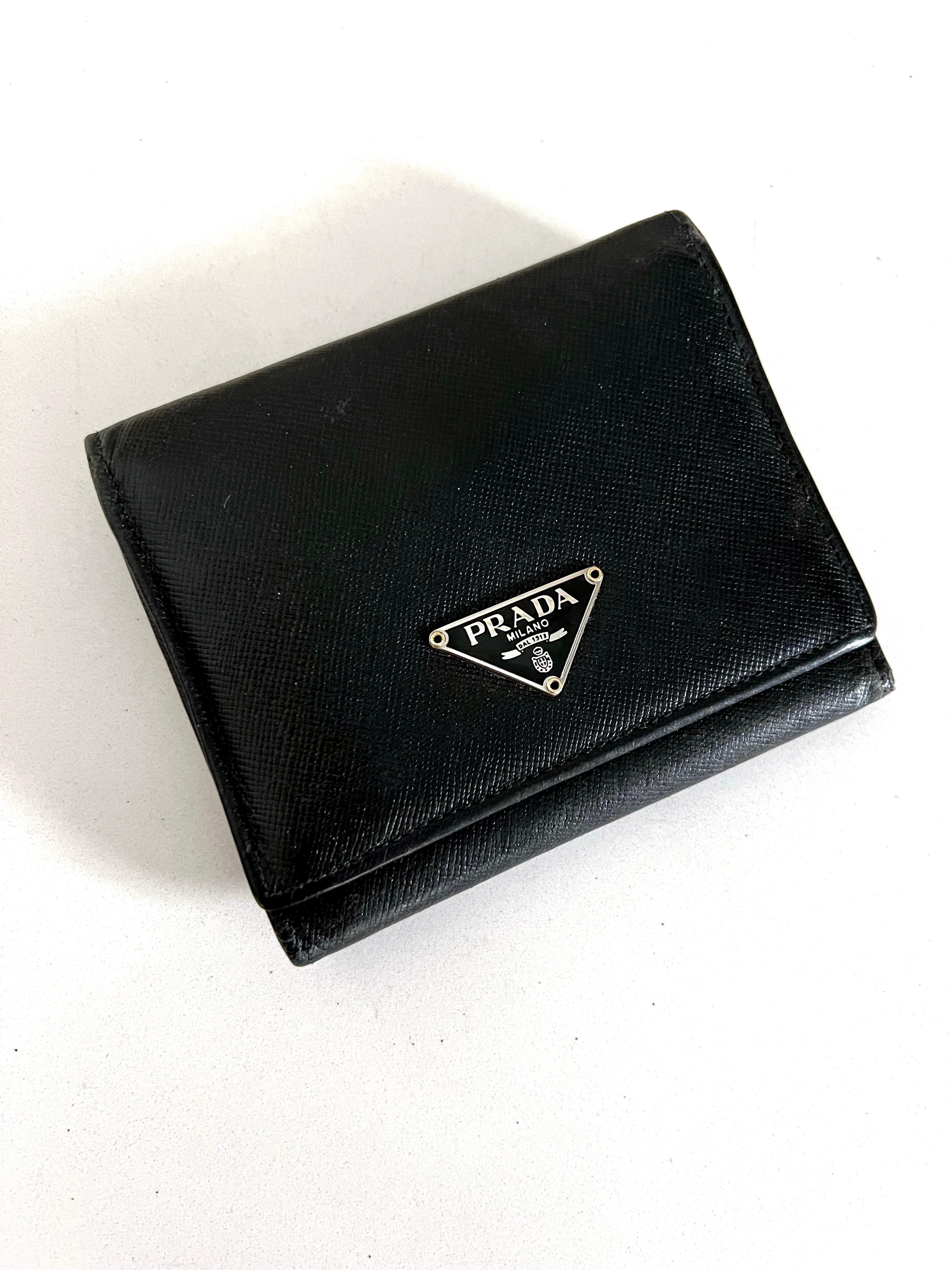 A wonderful and family un-used Prada Wallet... a more traditional mans size wallet, but great for anyone! The wallet easily holds, bills, change and has room for 6 credit cards and spaces for things like car registration, insurance cards, etc. a