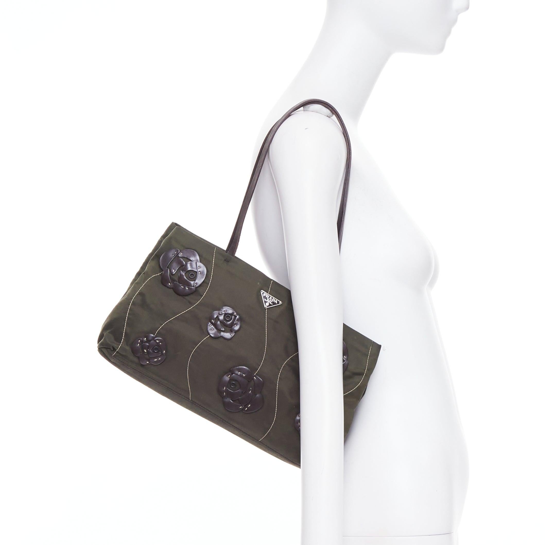 PRADA Vintage 1990s Flower navy green nylon brown floral applique shoulder bag
Referenz: TGAS/E00982
Marke: Prada
Designer: Miuccia Prada
Modell: Blume
MATERIAL: Nylon, Leder
Farbe: Grün, Braun
Muster: Floral
Verschluss: Reißverschluss
Innenfutter: