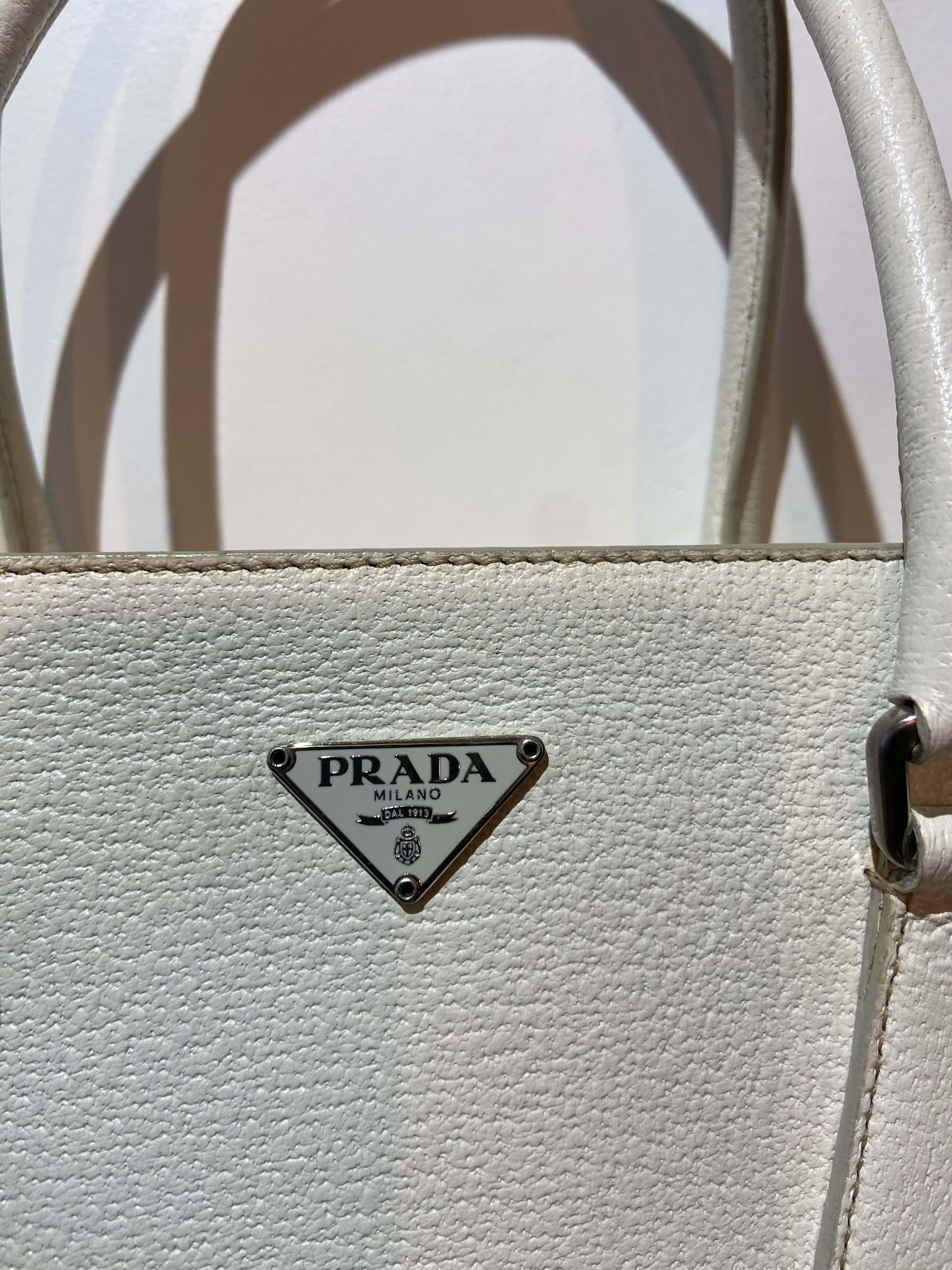 Vintage 2000's  Prada white leather tote bag. Feature a square shape, inner zip pocket. 

Brand: Prada
Color: White
Year / Season: 2000's
Tote Bag
Fabric: Leather
Dustbag: Yes
Serial Number: T
Measurements when laid flat: Length: 9.5 inches, Width: