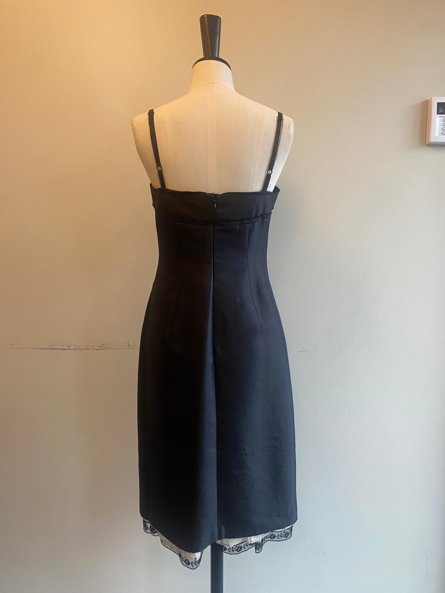 Vintage beaded dress from Prada. Black wool/silk mix upper in a tight fitting, bodice style evening dress with sheer, frilled nude hemline with black lace trim. Sleeveless style with silk ribbon straps and heavy beading along the bust. Made in