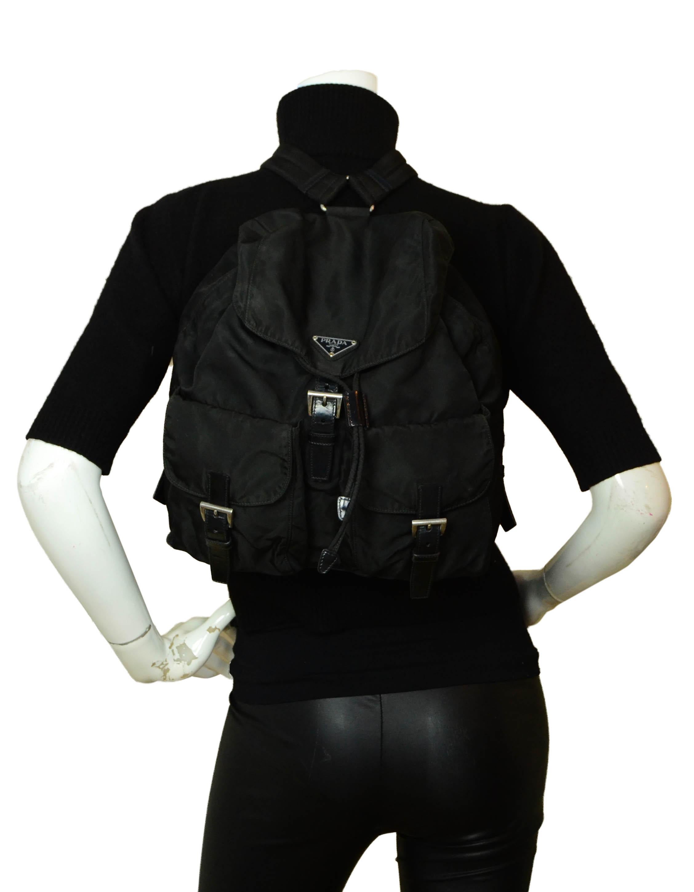 Prada Black Nylon Double Buckle Pocket Backpack Bag

Made In: Italy
Color: Black 
Hardware: Silvertone
Materials: Nylon with leather trim and canvas straps
Lining: Black logo textile 
Closure/Opening: Flap top with magnetic and buckle