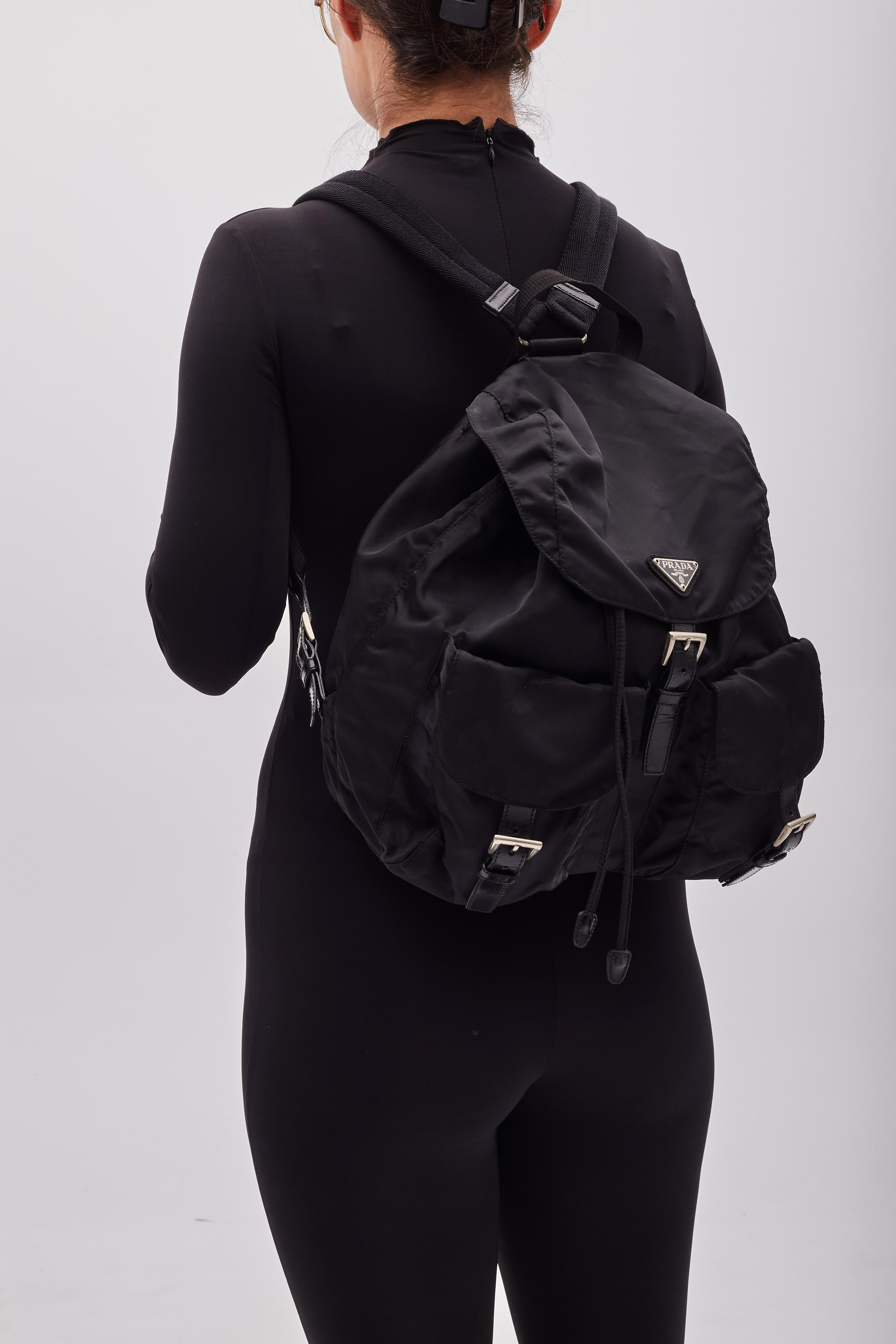 This Prada black Nylon Backpack is great for travel or running errands. The bag features signature black nylon fabric, leather trim, two front pockets and adjustable canvas straps.

Color: Black
Material: Nylon
Item code: 50
Model: B2811
Comes with: