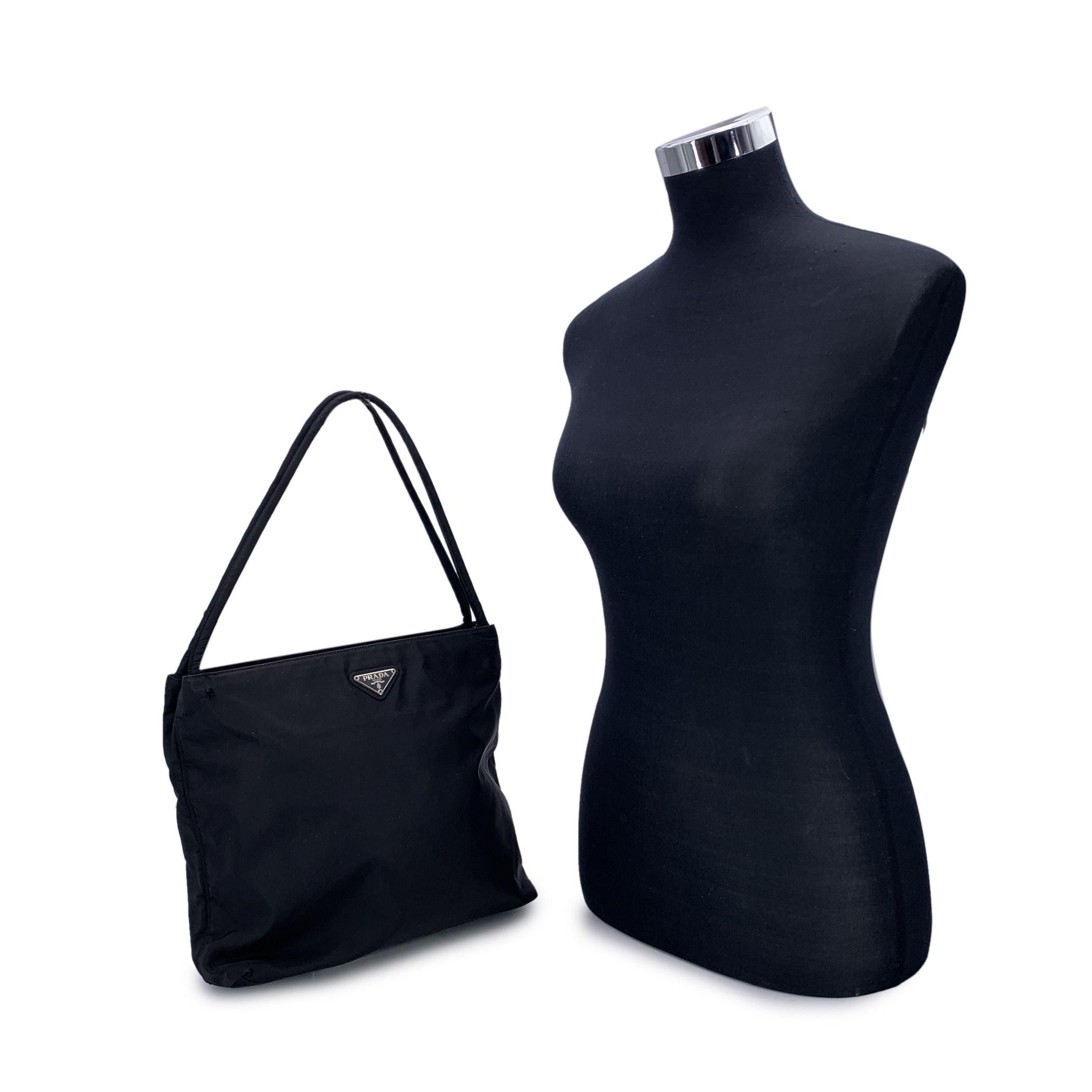 Step into the world of understated luxury with the elegant Prada Tessuto Nylon Tote Bag, a perfect fusion of timeless design and practicality. Crafted from sleek black nylon, this tote offers both durability and sophistication, making it an ideal