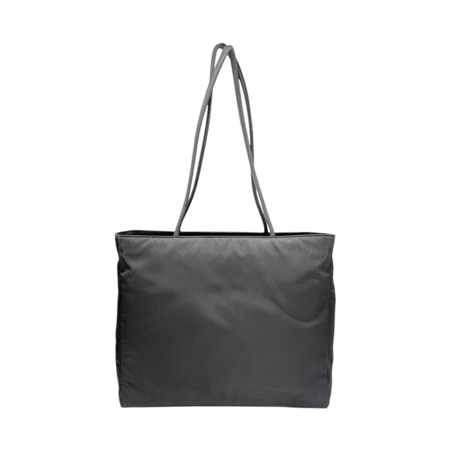 Experience luxury and style with the Prada Enameled Metal Triangle Nylon Tote. Made with high quality black nylon with the iconic signature touch of the enameled metal triangle logo, this tote exudes elegance and sophistication. Its spacious