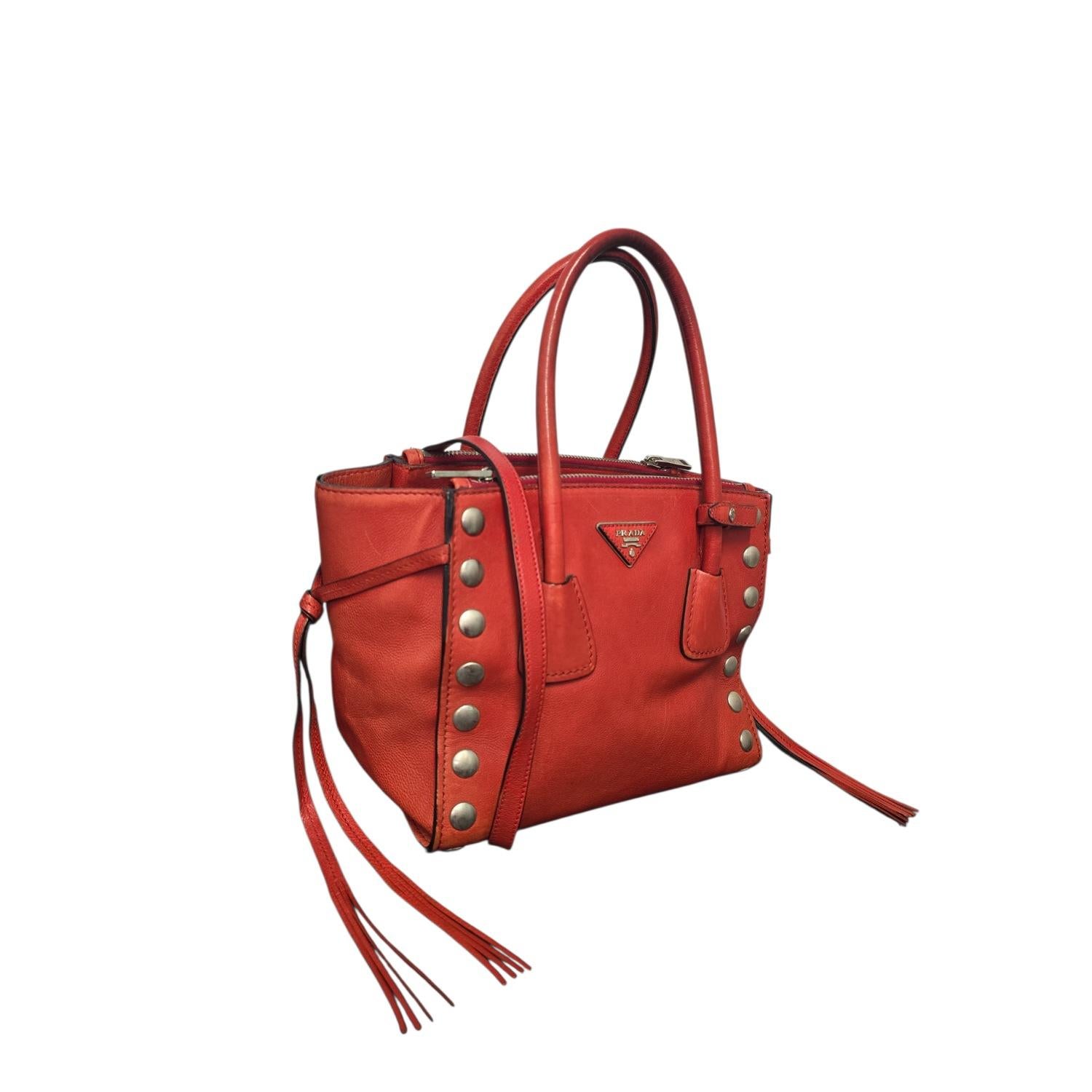 Ce sac à main Prada Glace Calf Twin Pocket est magnifiquement réalisé en luxueux cuir de veau glacé de couleur rouge Galleria. Le sac à bandoulière présente des poignées supérieures en cuir roulé avec une bandoulière en cuir optionnelle détaillée et