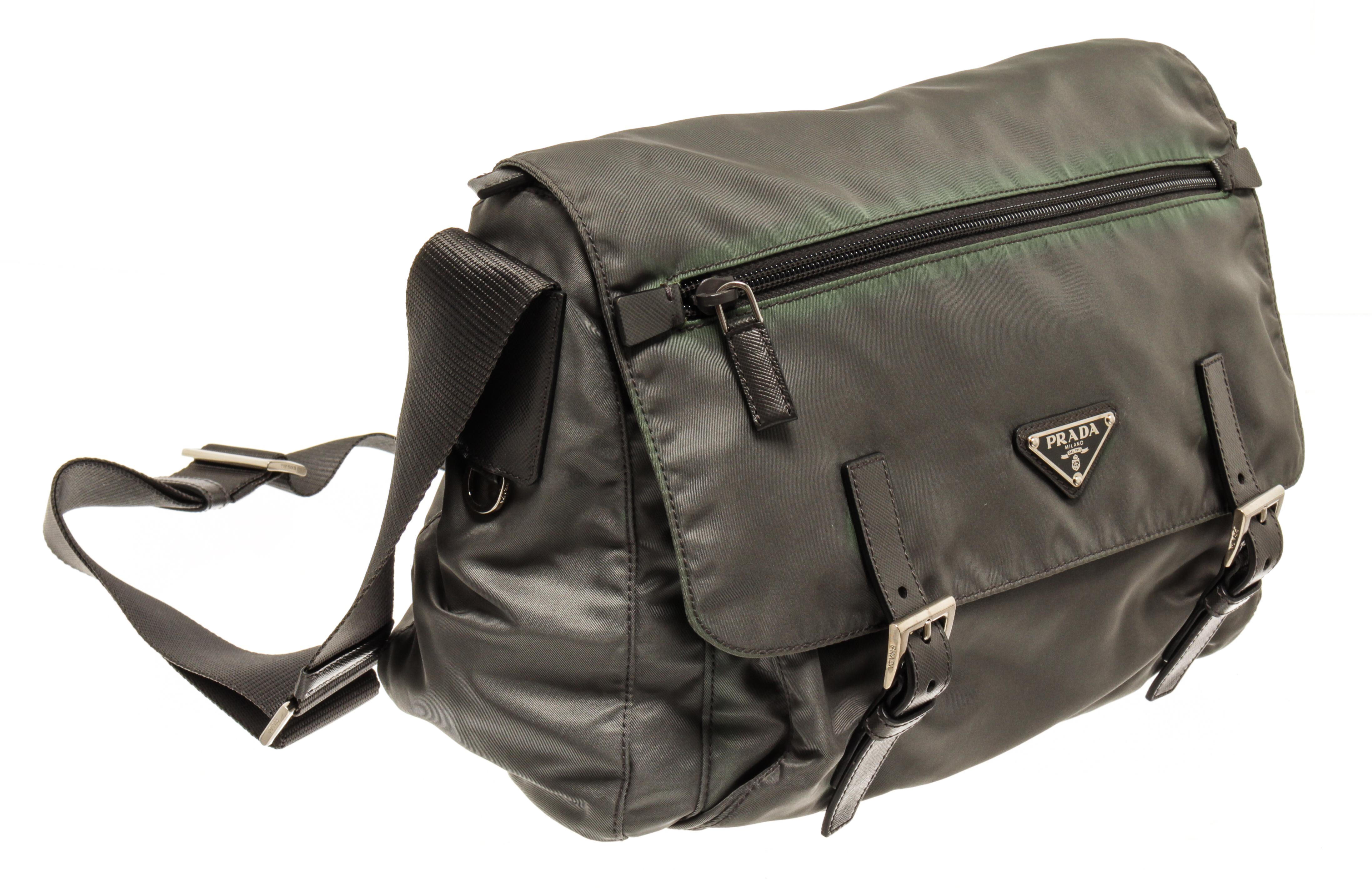 Prada vintage grey nylon messenger bag with zipper, flap, and buckle closure; two exterior zip pockets (one on the flap, one under the flap), one interior zip pocket, adjustable long strap, silver-tone hardware, and black fabric lining. 

80710MSC