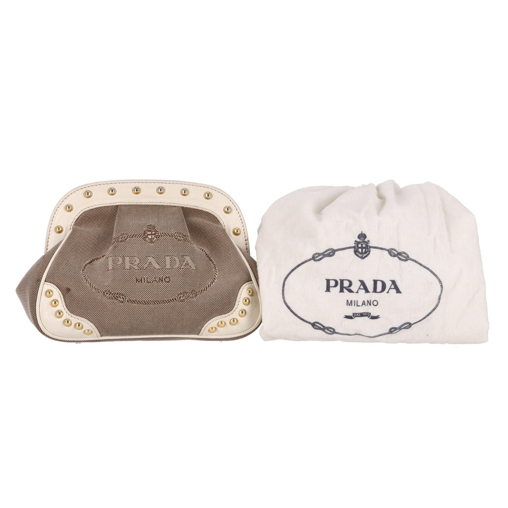 Prada Vintage Jacquard Studded Logo Clutch Bag 

Dark beige jacquard with cream leather trims embellished with gold studs.

'Prada Milano' signature embroidery to the front.

Featuring press-stud closure leading to satin logo lined interior.

Rrp