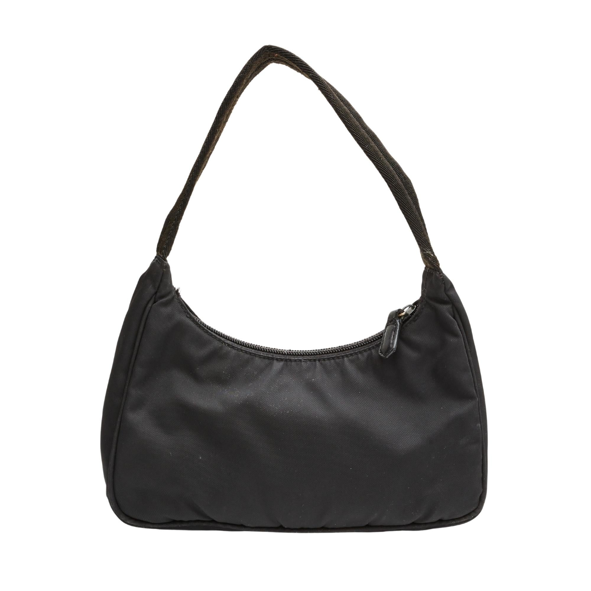 Prada mini bag made with nylon in a hobo style. Featuring zip zip closure, black woven fabric looping shoulder strap and black lining.

COLOR: Black
MATERIAL: Nylon
ITEM CODE: 46
MEASURES: H 6” x L 9” x D 2.5”
DROP: 7”
COMES WITH: Dust