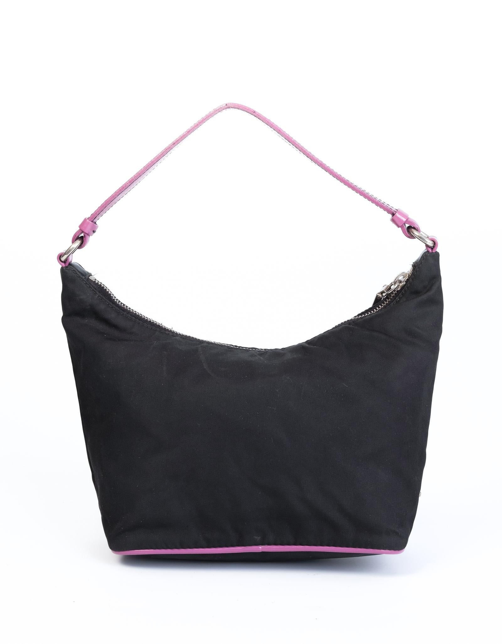 This shoulder bag features a nylon body with leather trim and front pocket in playful pink, a flat pink leather strap, a top zip closure and an interior zip pocket.

COLOR: Black
MATERIAL: Tessuto nylon
ITEM CODE: 31
MEASURES: H 3.5” x L 5” x D