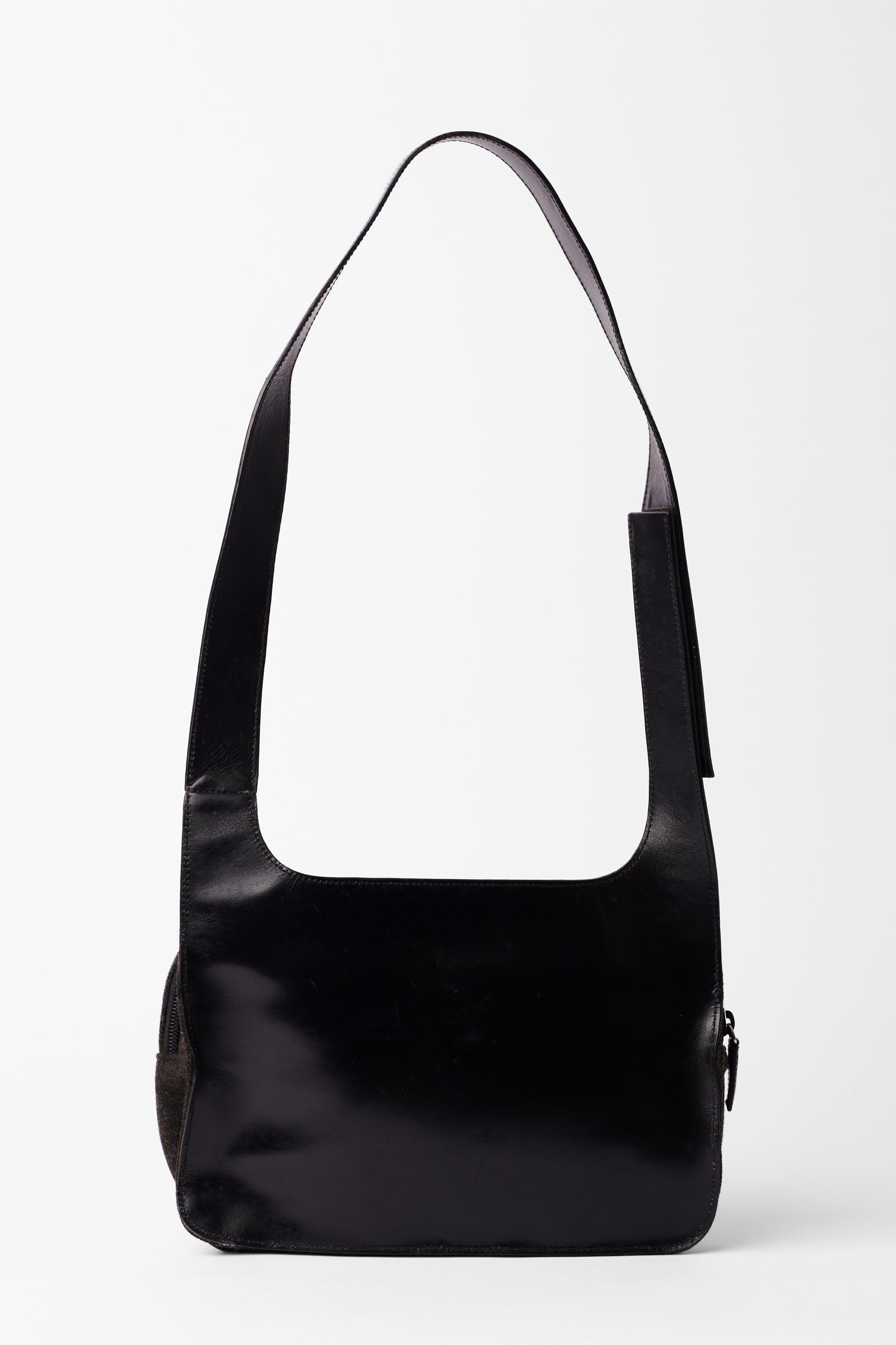 Vintage Prada Spring Summer 1999 grey wool shoulder bag. Features dual-wear shoulder and cross body strap, velcro closure, wool body with leather 'Prada' and inner zip back closure. In excellent vintage condition. 
Brand: Prada
Color: Grey
Fabric: