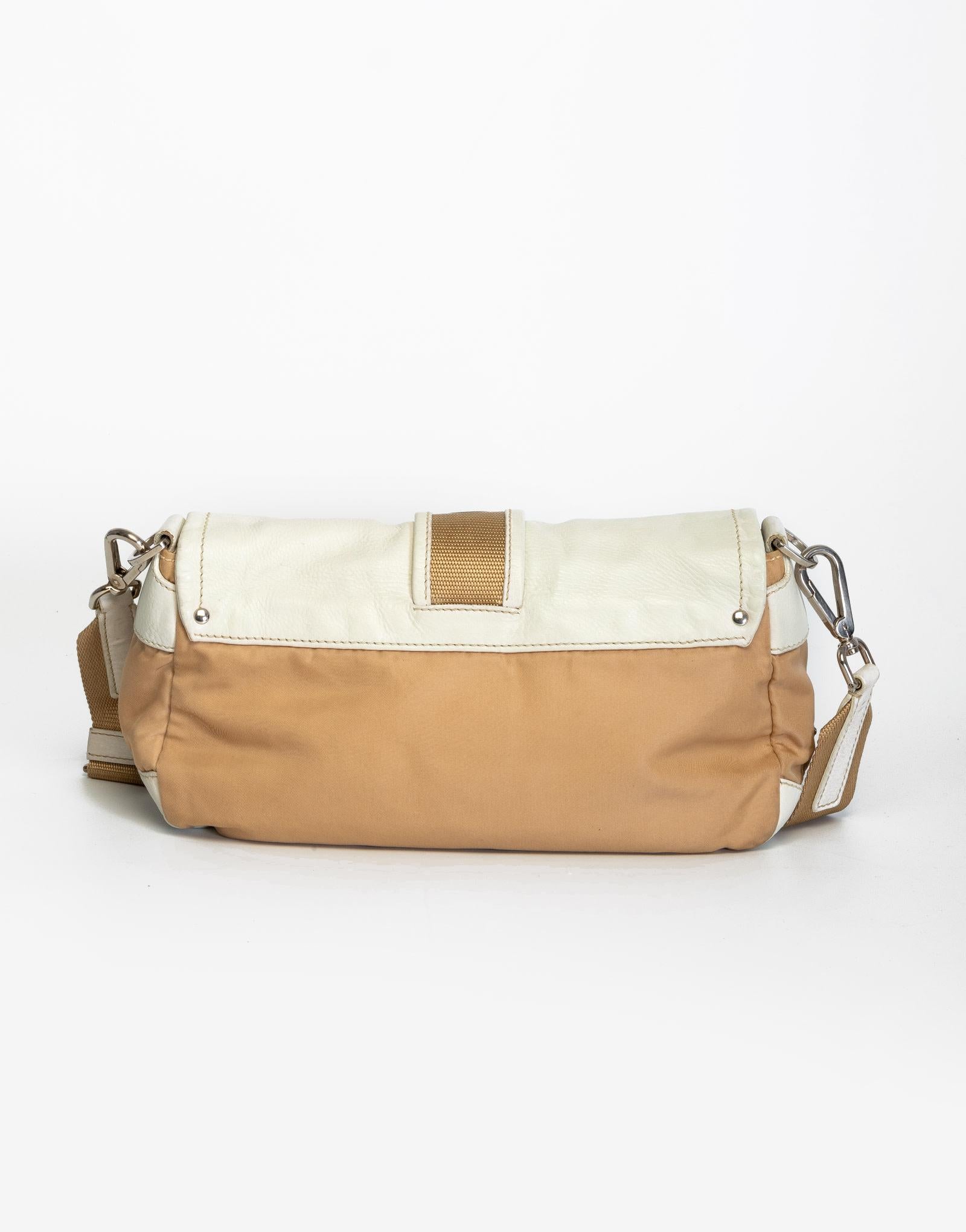 This bag features a cream and beige nylon body, leather trim and a front buckle to secure the top flap with magnetic snap closure.

COLOR: Cream and beige
MATERIAL: Nylon & leather
ITEM CODE: 31
MEASURES: H 5.5” x L 10.5” x D 3.5”
EST. RETAIL: