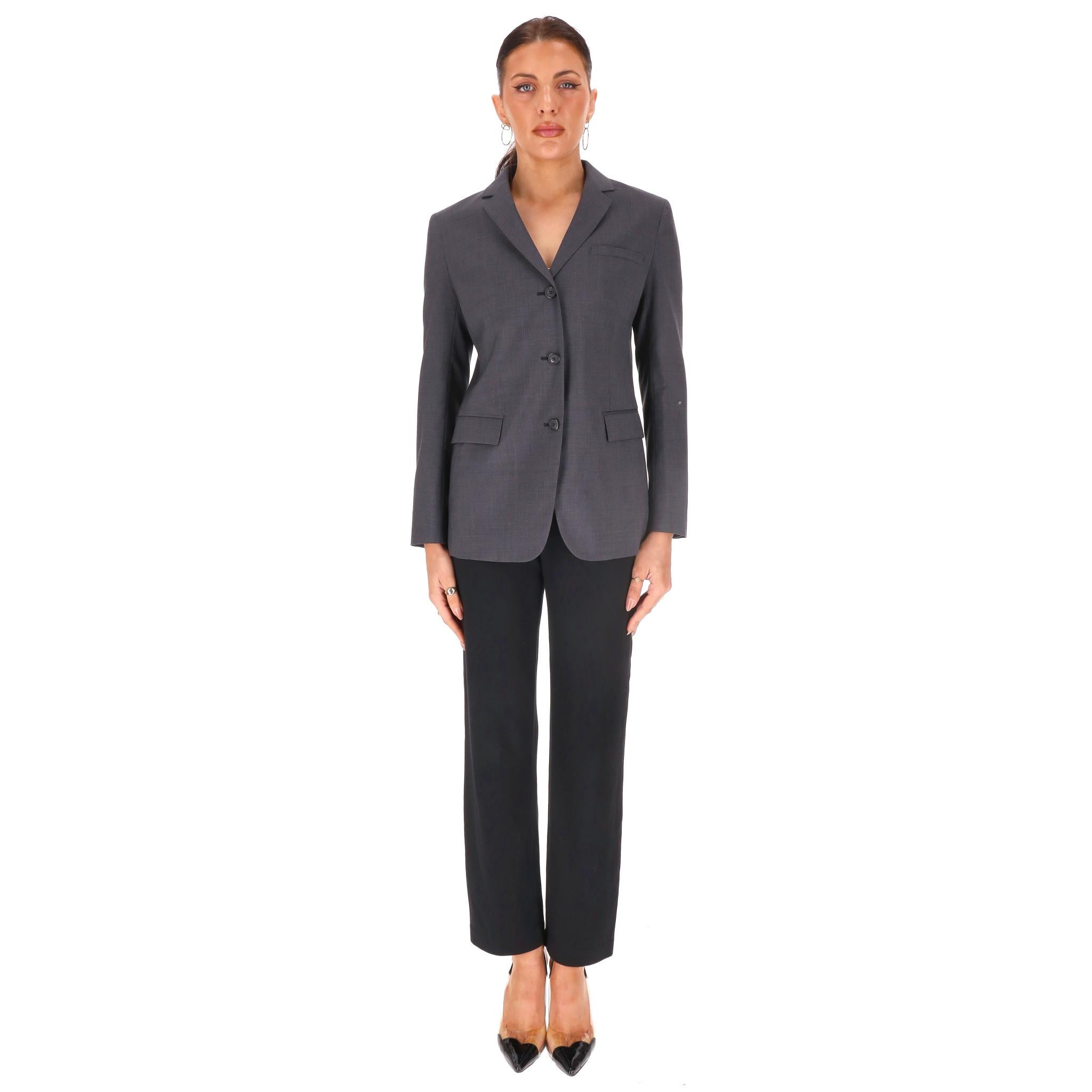 Blazer/Giacca in lana vergine di Prada

Blazer in lana grigia con chiusura frontale a monopetto con bottoni, colletto classico e silhouette sartoriale più lunga con spacco posteriore.

Completamente foderato e con passanti per la cintura inclusi,
