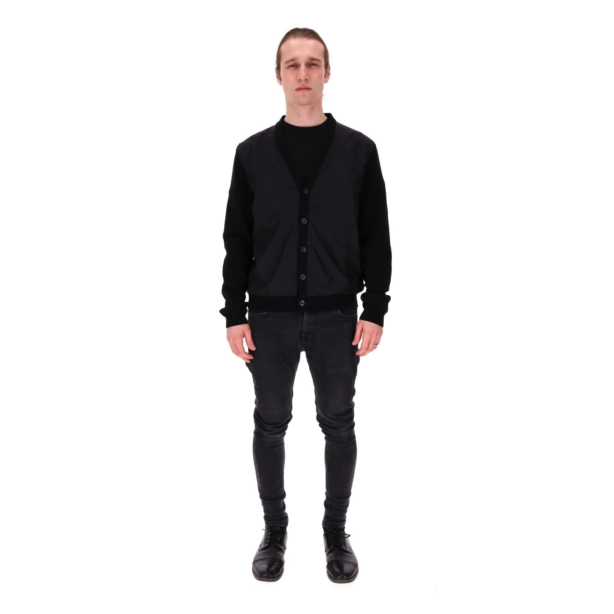 Prada Virgin Wool Cardigan

Black cardigan designed with virgin wool sleeves, trims and rear with tonal nylon panel to the front.

Featuring button centre closure, V-neck and ribbed cuffs and hem.

Rrp Approx. £1,800

Size – 52IT

Condition – Very