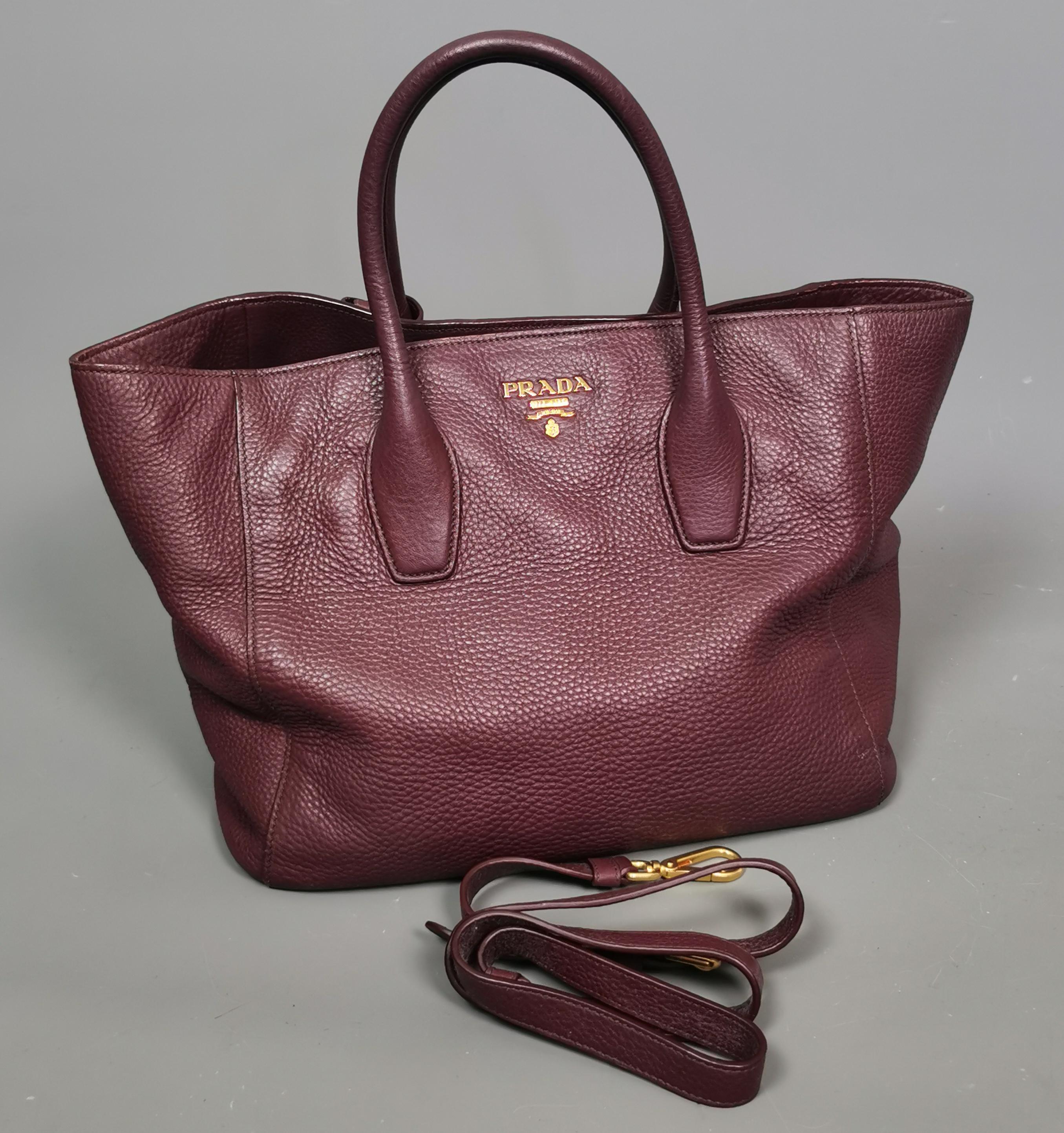 A simply gorgeous Prada Vitello Daino burgandy leather shopper or tote bag. 

A great sized bag with plenty of room to add your days essentials, the bag is convertible as it can also be worn as a shoulder bag and comes with the original shoulder