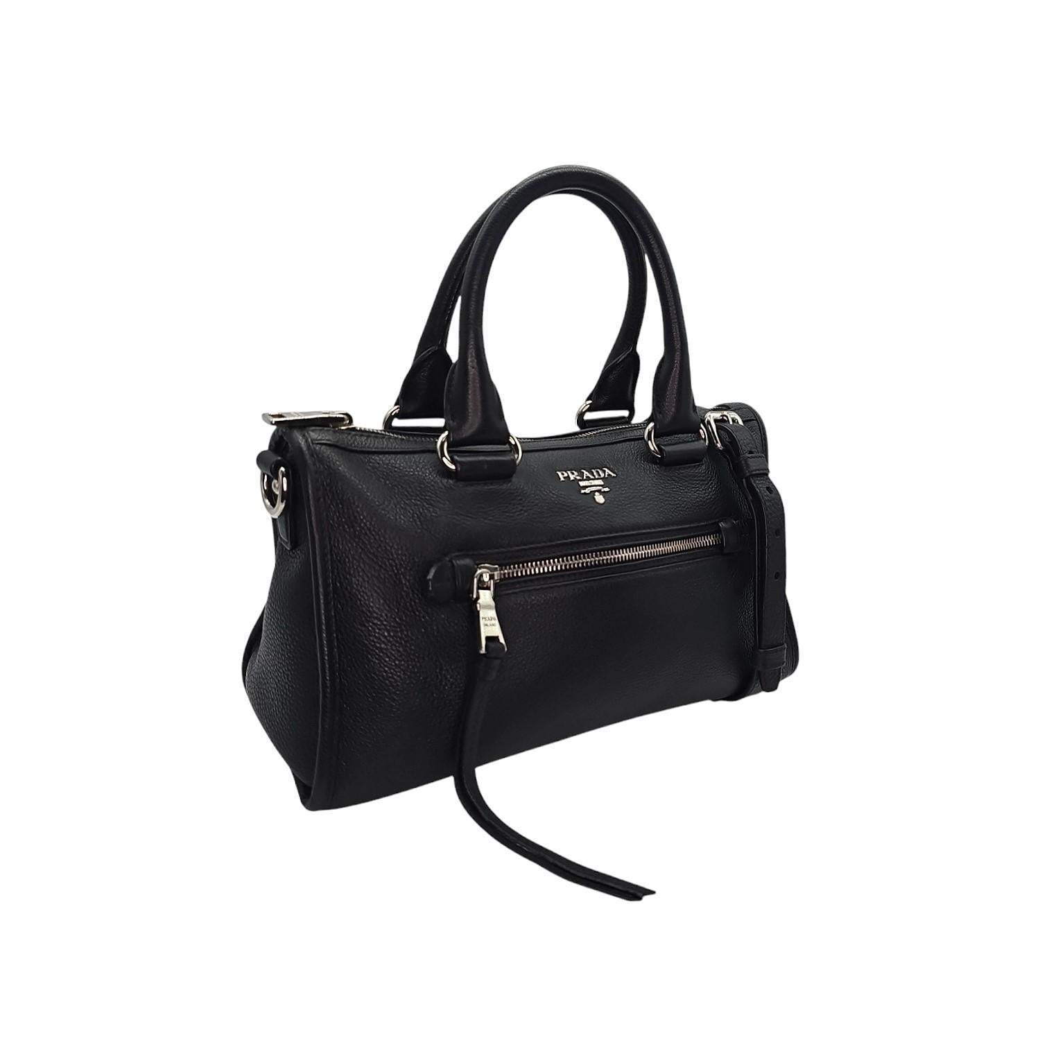 Erhöhen Sie Ihren Stil mit der Prada Vitello Daino Phenix Nero Handtasche. Diese Tasche aus strukturiertem, gekörntem Leder verfügt über ein Reißverschlussfach auf der Vorder- und Rückseite, gerollte Griffe, silberfarbene Beschläge und ein