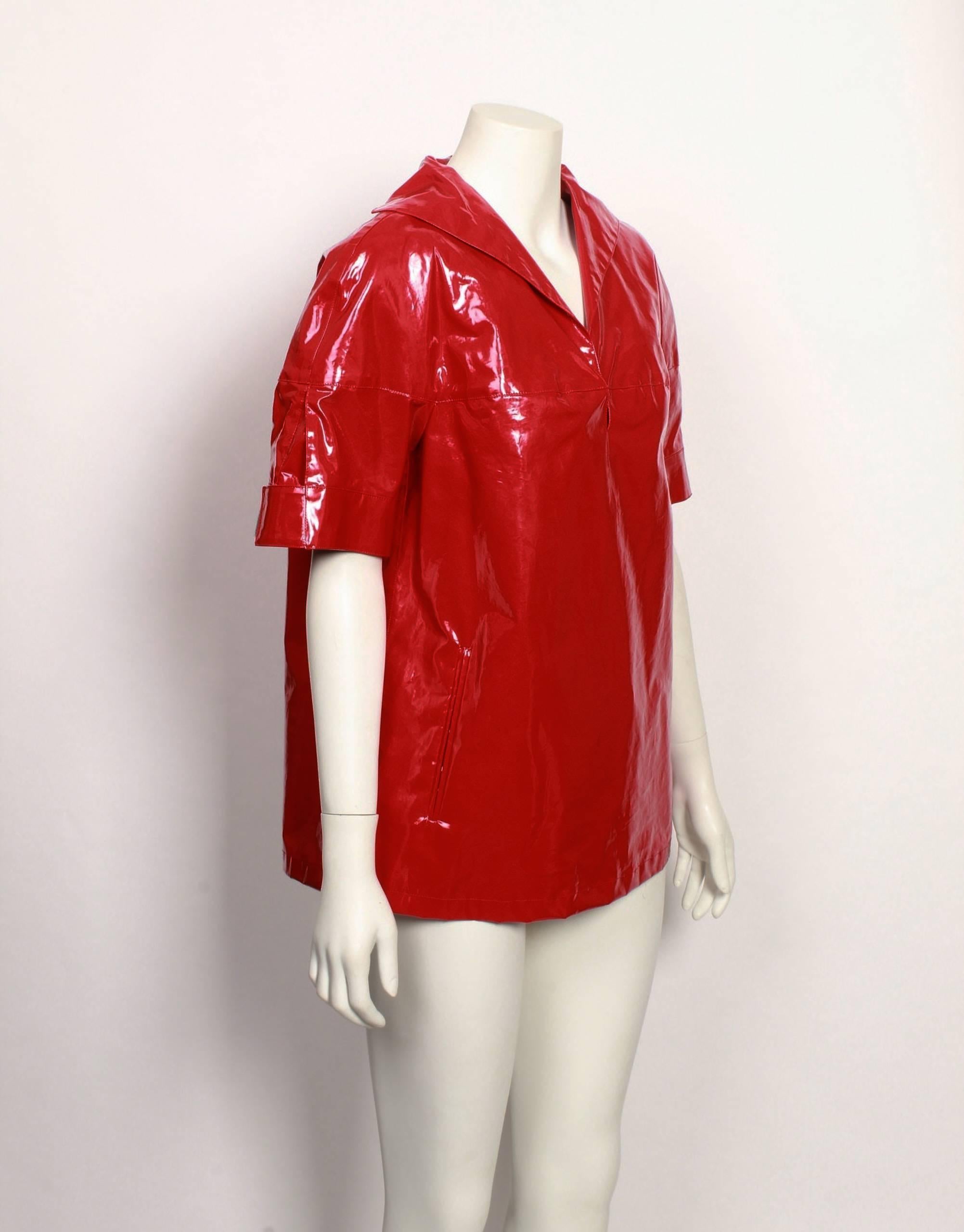 Prada futuristic bright red high shine cotton vinyl waterproof shell top with turn back collar, 2 front pockets and adjustable sleeves with velcro tabs.  This item has never been worn. Original tags still attached.
Made in Italy. Size 40.
Classic