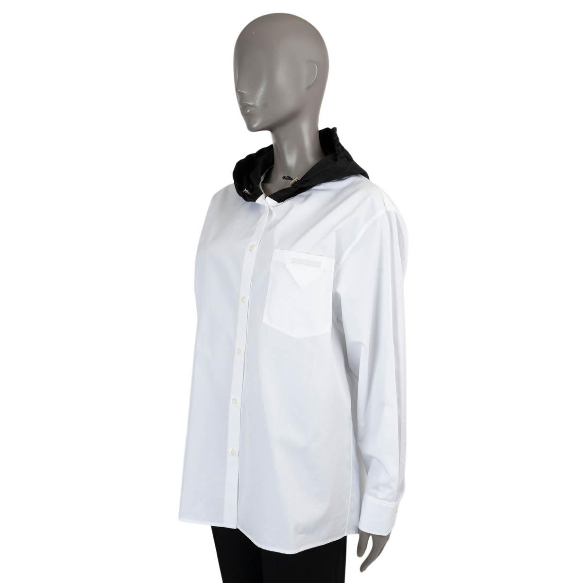 100% authentic Prada button-up shirt in white cotton (100%). Features a black hood in re-nylon, a chest pocket with triangle patch and logo label. Has been worn and is in excellent condition. 

2022 Pre-Fall

Measurements
Tag