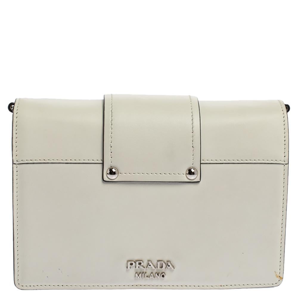 High on style, carry this bag from Prada without compromising on style. Look stunning with this bag crafted from quality leather. It has a front flap with ribbon-like detailing and the brand logo. It opens to a spacious nylon-lined interior with a