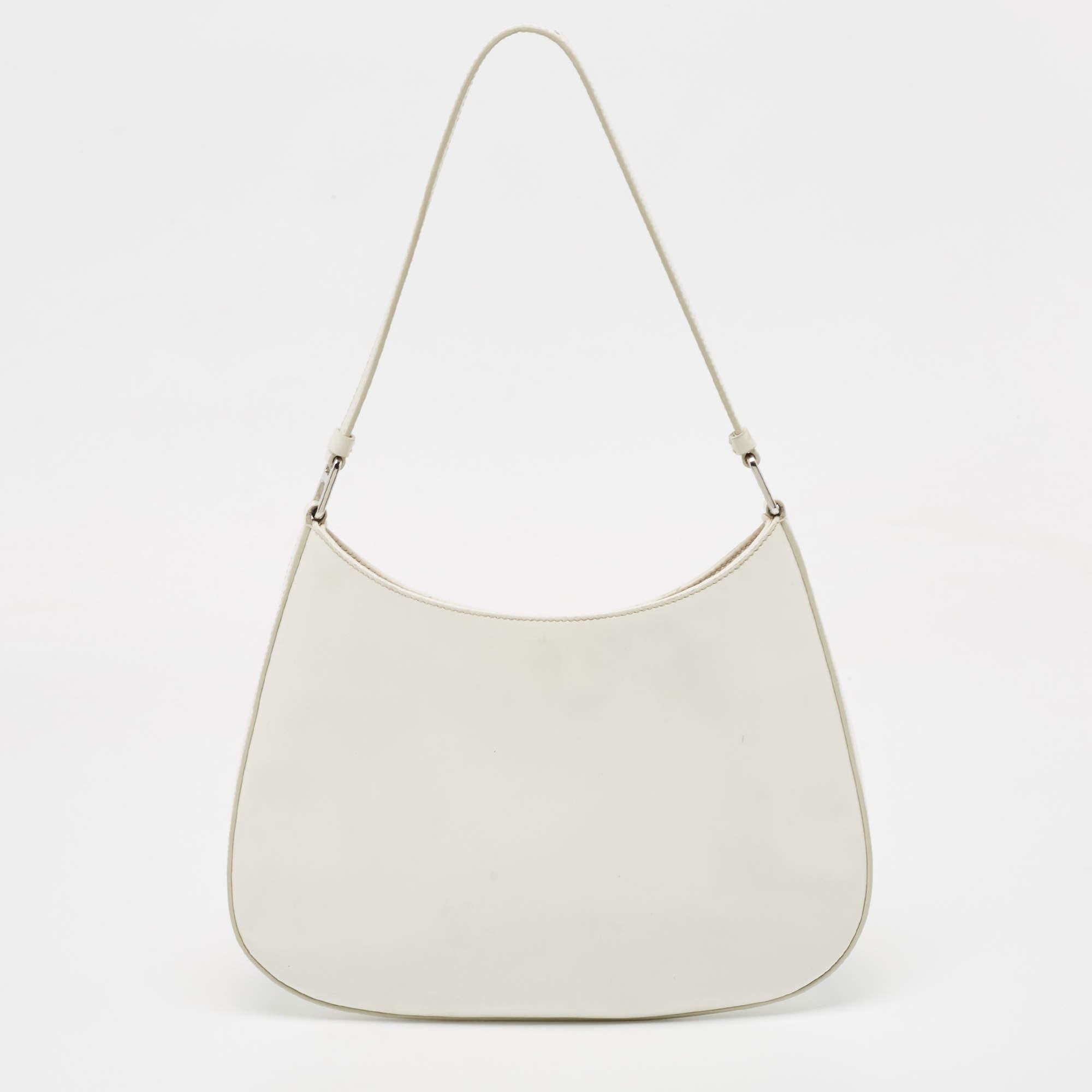 This Prada Cleo bag showcases the label's classy design attributes. It is made from leather in a white hue and added with the brand logo and a top handle.

