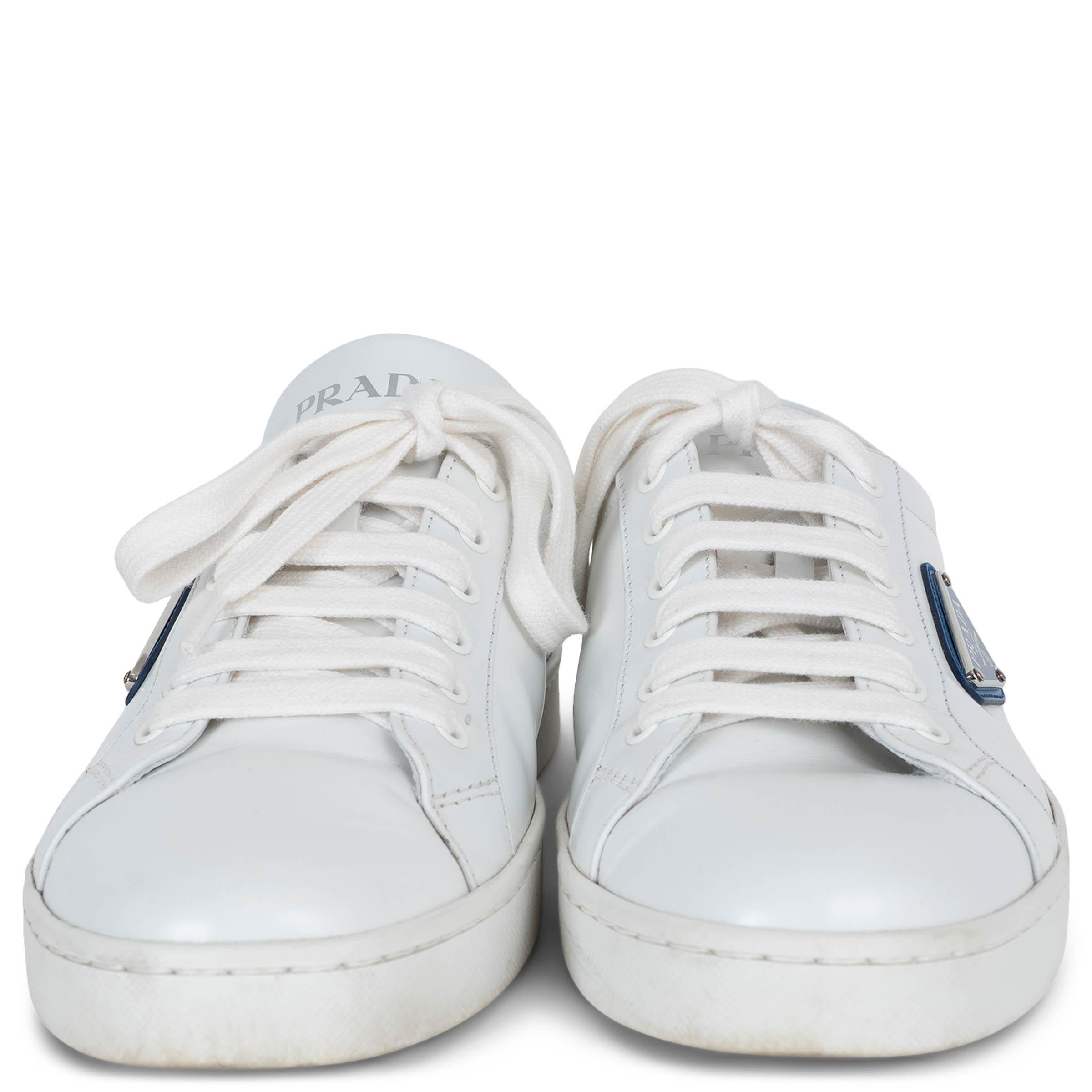 Dieser 100% authentische Prada Lane's Low-Top-Sneaker ist aus weißem gebürstetem Leder gefertigt und mit einem kobaltblauen Lederstreifen an der Ferse versehen. Er verfügt über das ikonische dreieckige Emaille-Logo der Marke an der Seite in