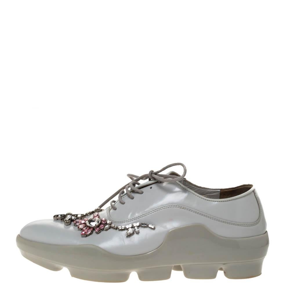 Prada delivers statement and comfort with these sneakers. Crafted from quality leather, they come in a lovely shade and are styled with pointed toes, crystal embellishments, lace-up vamps, silver-tone hardware and durable rubber soles.

