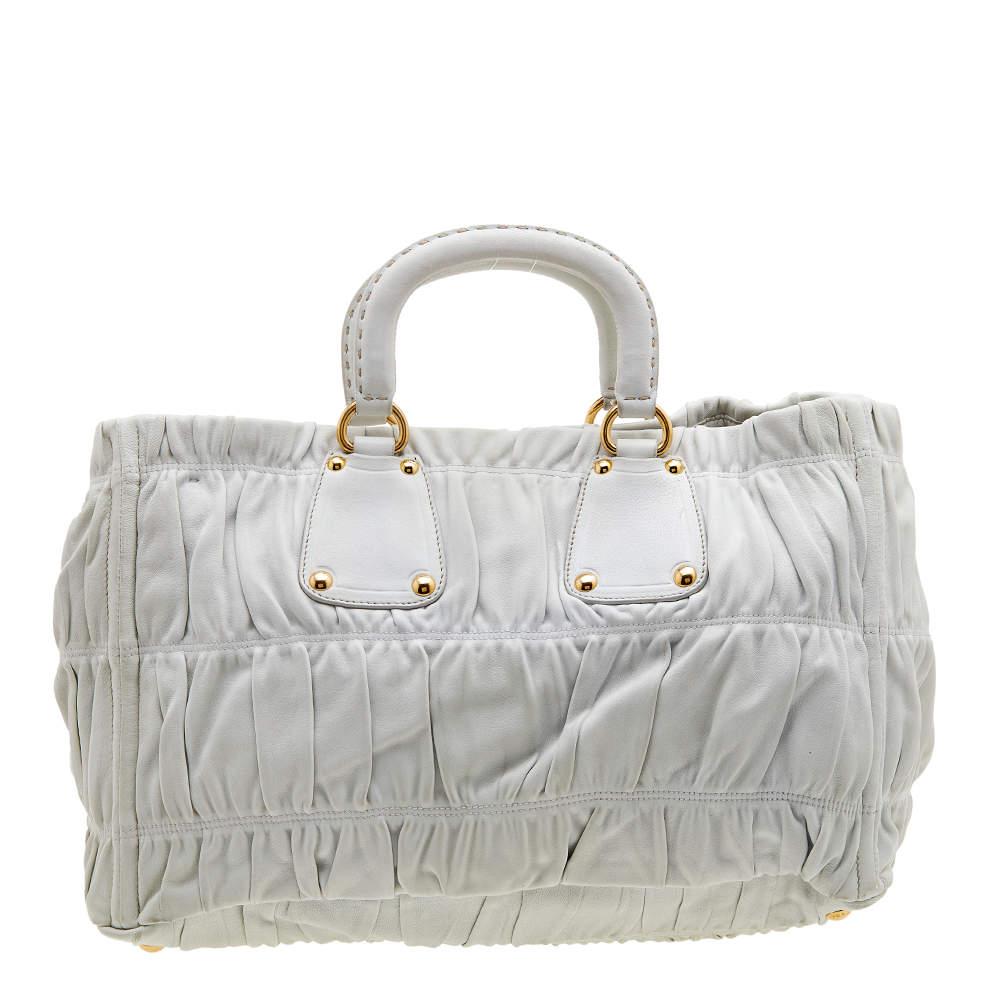 Prada brings you this lovely tote that has been crafted from leather in white. It has a well-sized nylon interior and the bag is complete with two top handles and an optional shoulder strap. Stylish and ideal for daily use, this bag is a worthy