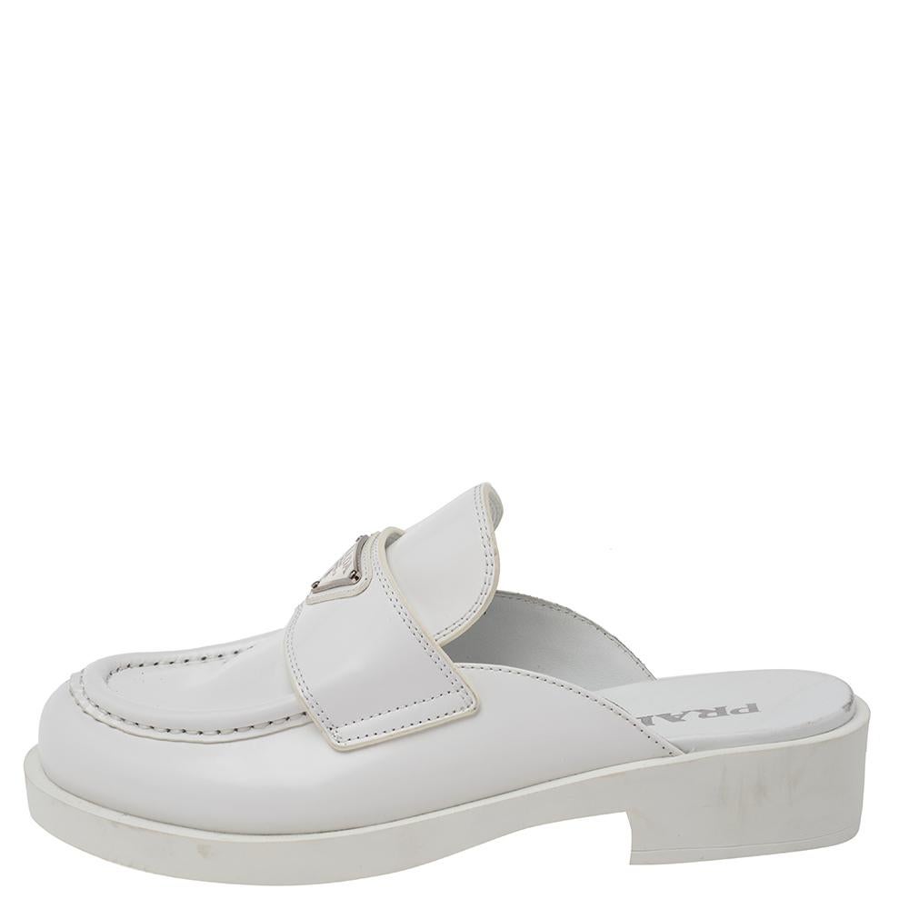 The House of Prada, with these super creative, comfortable mules, is here to offer your feet with never-ending style. These mules are designed using white leather on the exterior with a silver-toned logo plaque perched on the vamps. Featuring a