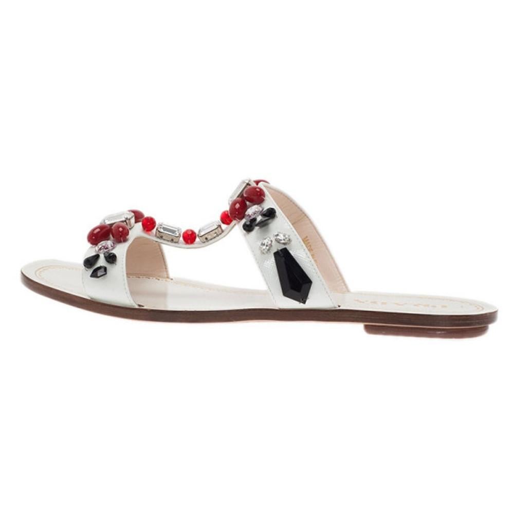 Add these Prada Saffiano Leather Flat Sandals to a casual look for the perfect finishing touch. Crafted from classic Prada saffiano leather in white, these sandals are coupled with colorful beaded t-straps with crystal embellishing and open toes.