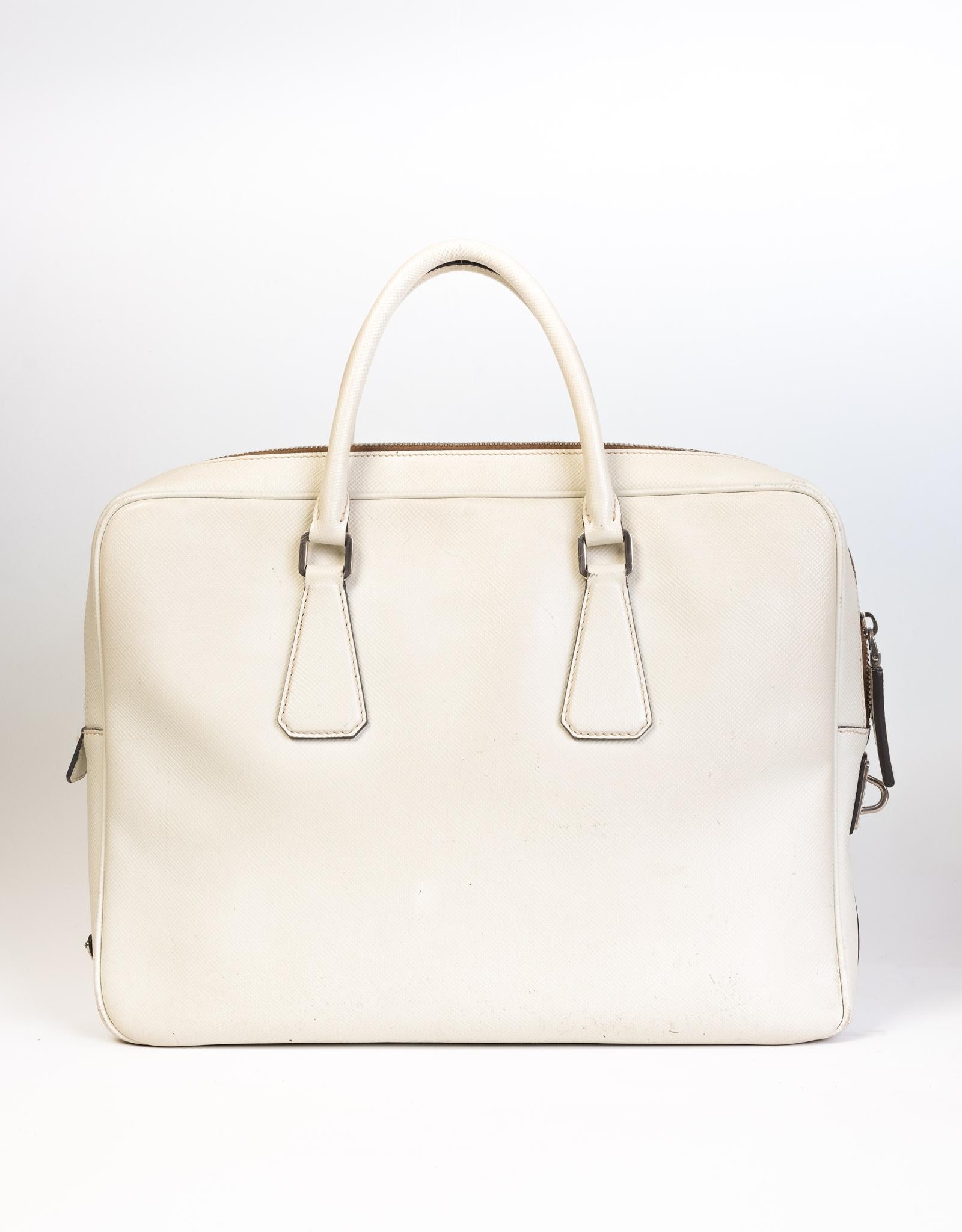Diese Aktentasche ist aus quer genarbtem Saffiano-Leder in Weiß gefertigt. Es  mit gerollten Ledergriffen und silberner Hardware. Hat das Prada-Logo auf der Unterseite. 

FARBE: Weiß
MATERIAL: Leder
ITEM CODE: 711
ABMESSUNGEN: H 11
