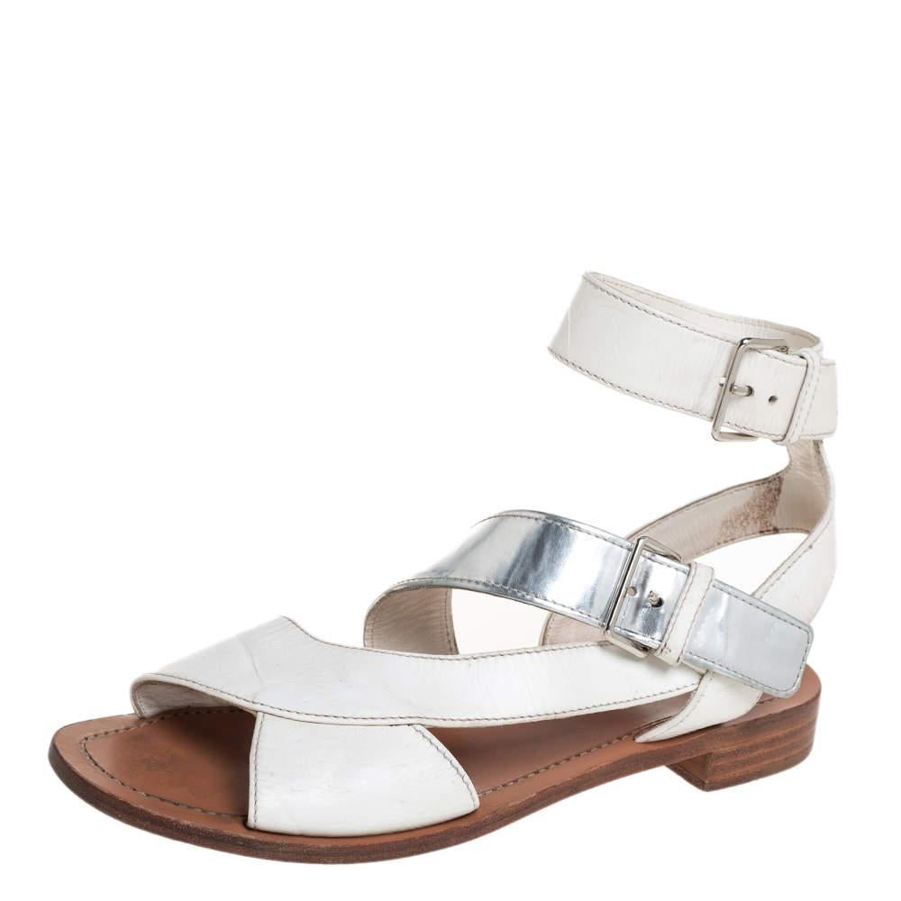 Modernas, cómodas y elegantes, estas sandalias de Prada son imprescindibles en tu armario. Están confeccionados en piel con un diseño de tiras y presentan tonos blancos y plateados. Combínalos con pantalones y tops recortados para un look chic.
