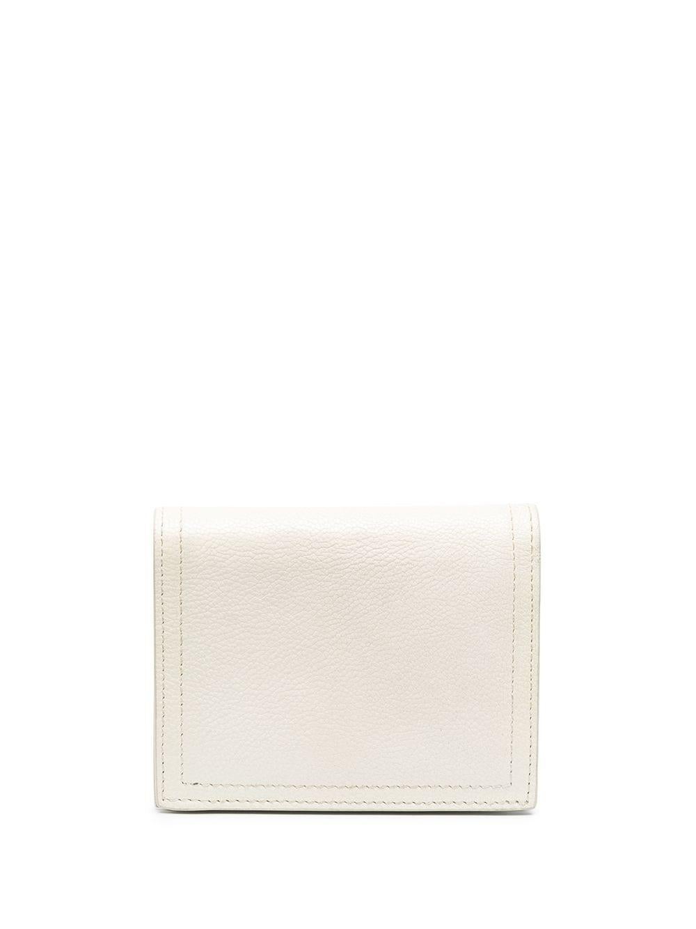 Beautifully sweet and simple coin purse from Prada in off-white leather. The purse opens up to card slots, and a contrasting blue coin section, as well as a notes compartment along the top. For security, the purse closes with a snap button.

Colour: