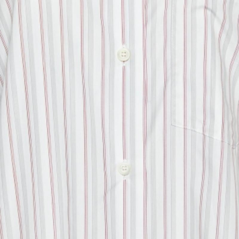 Confectionnée avec précision, cette chemise Prada allie luxe et fonctionnalité sans effort. Il présente des rayures et un détail de cravate au niveau du col qui lui confère une finition particulière.
