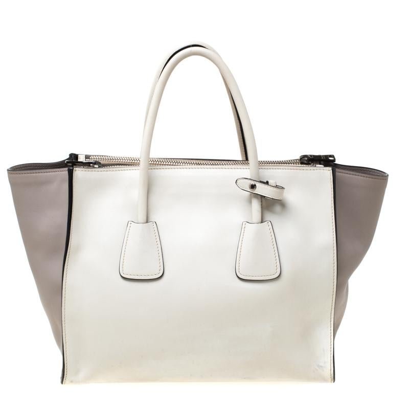 Feminine in shape and grand on design, this Double Zip tote by Prada will be a loved addition to your closet. It has been crafted from leather and styled minimally with silver-tone hardware. It comes with two top handles, two zip compartments and a