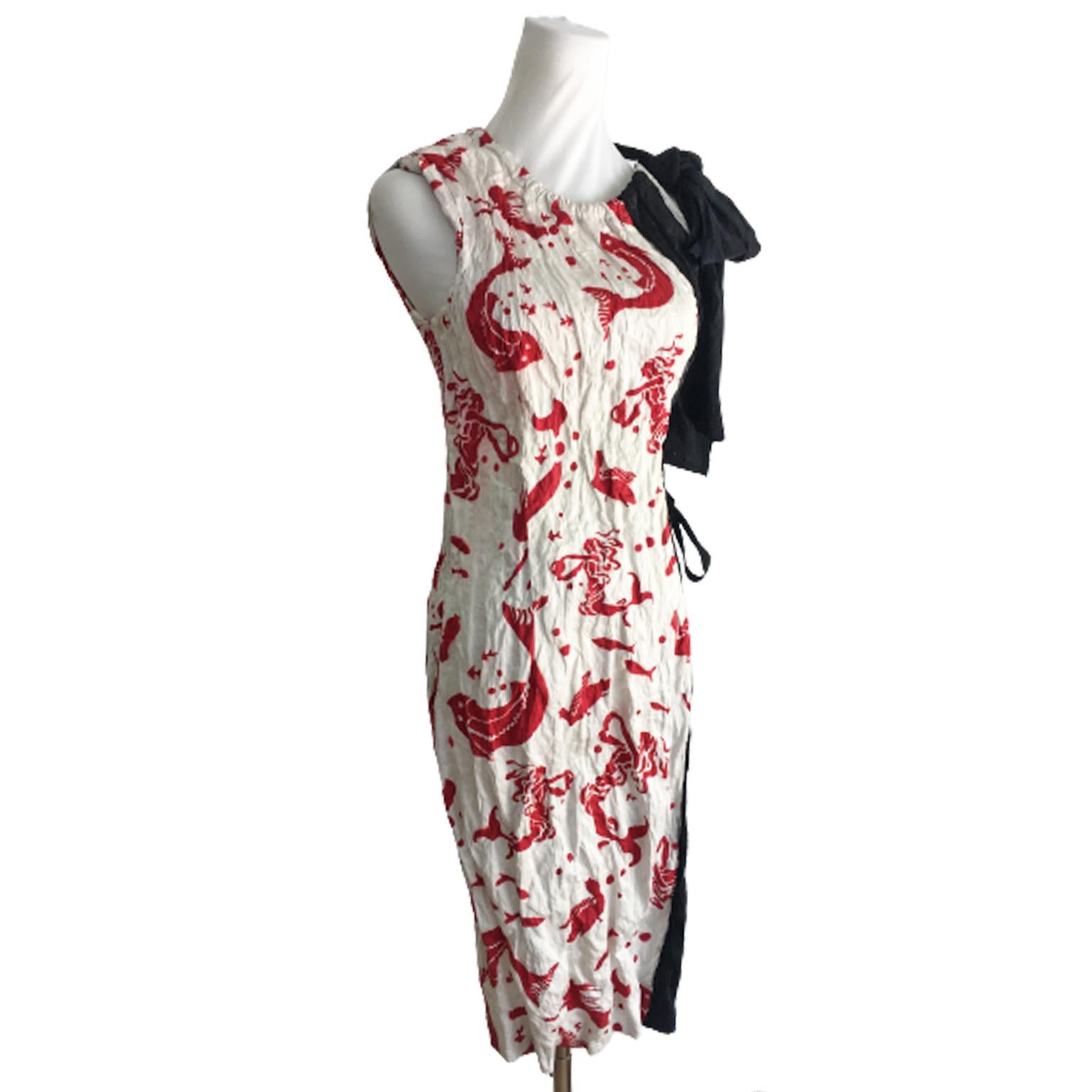 Prada dress from s/s 2009. Beautiful stencil like fish and mermaid print with black bow on one shoulder. Because of its construction and crinkled texture, it fits small to medium. With drawstring and push buttons fastening on the side. 
Size 44 (IT)