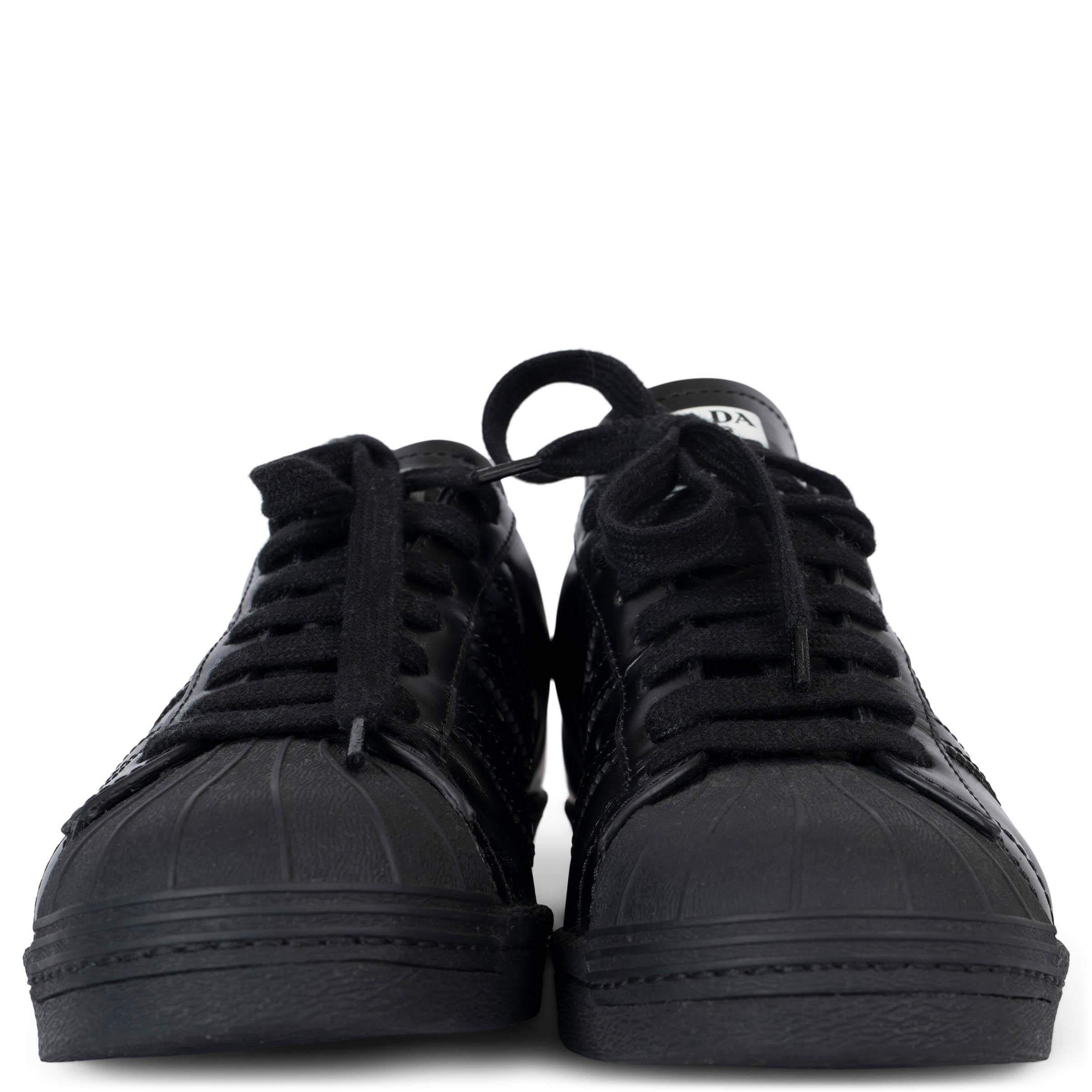 This 100% authentic adidas Superstar Prada Black sneaker is the result of a unique collaboration between two iconic brands, blending adidas's classic style with Prada's luxury craftsmanship. The sneaker features a premium black leather upper with