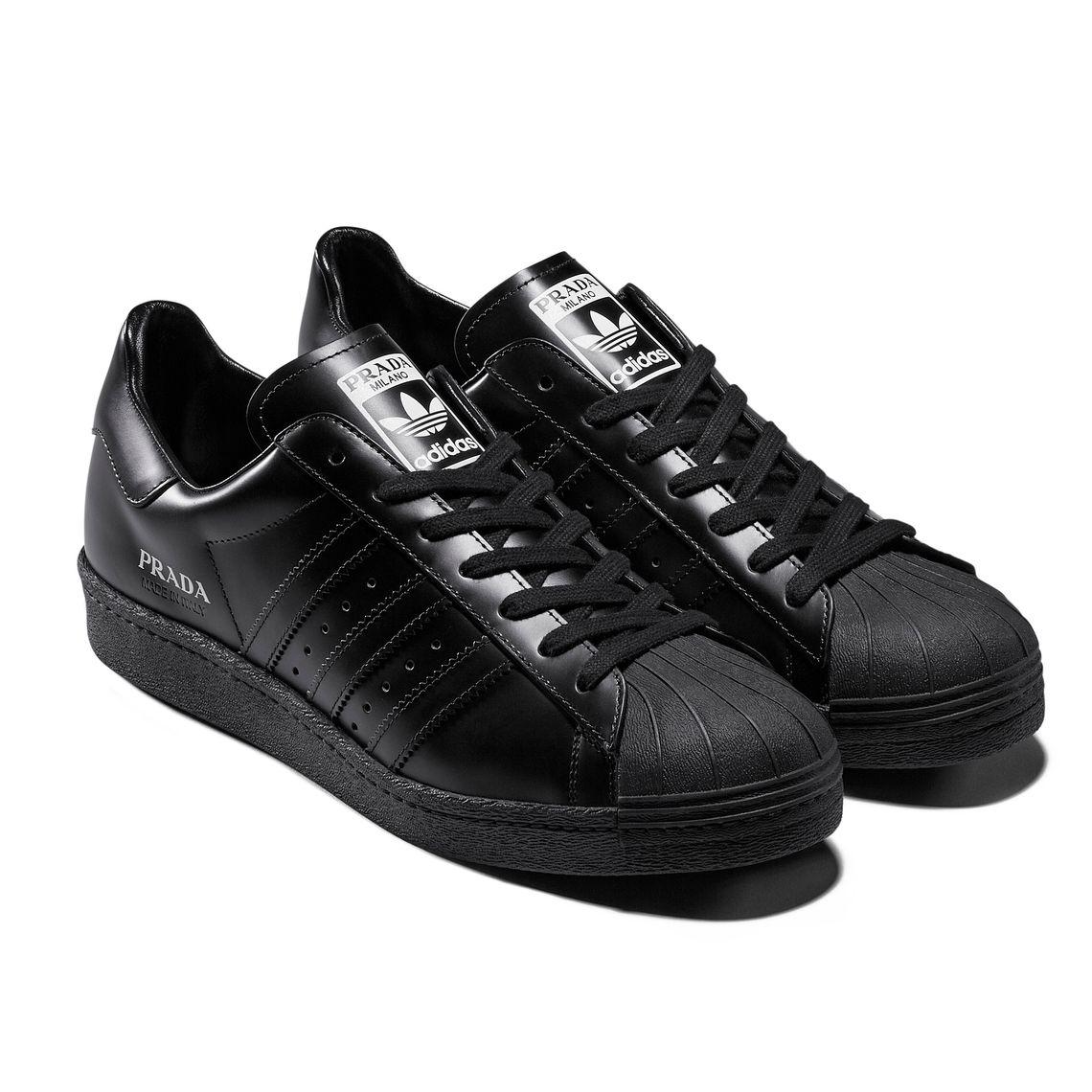 Low-top buffed leather sneakers in black. Round rubber cap toe. Tonal lace-up closure. Logo printed in white at padded tongue. Padded collar. Perforated detailing and signature serrated stripes at sides. Logo printed in white at outer side. Logo