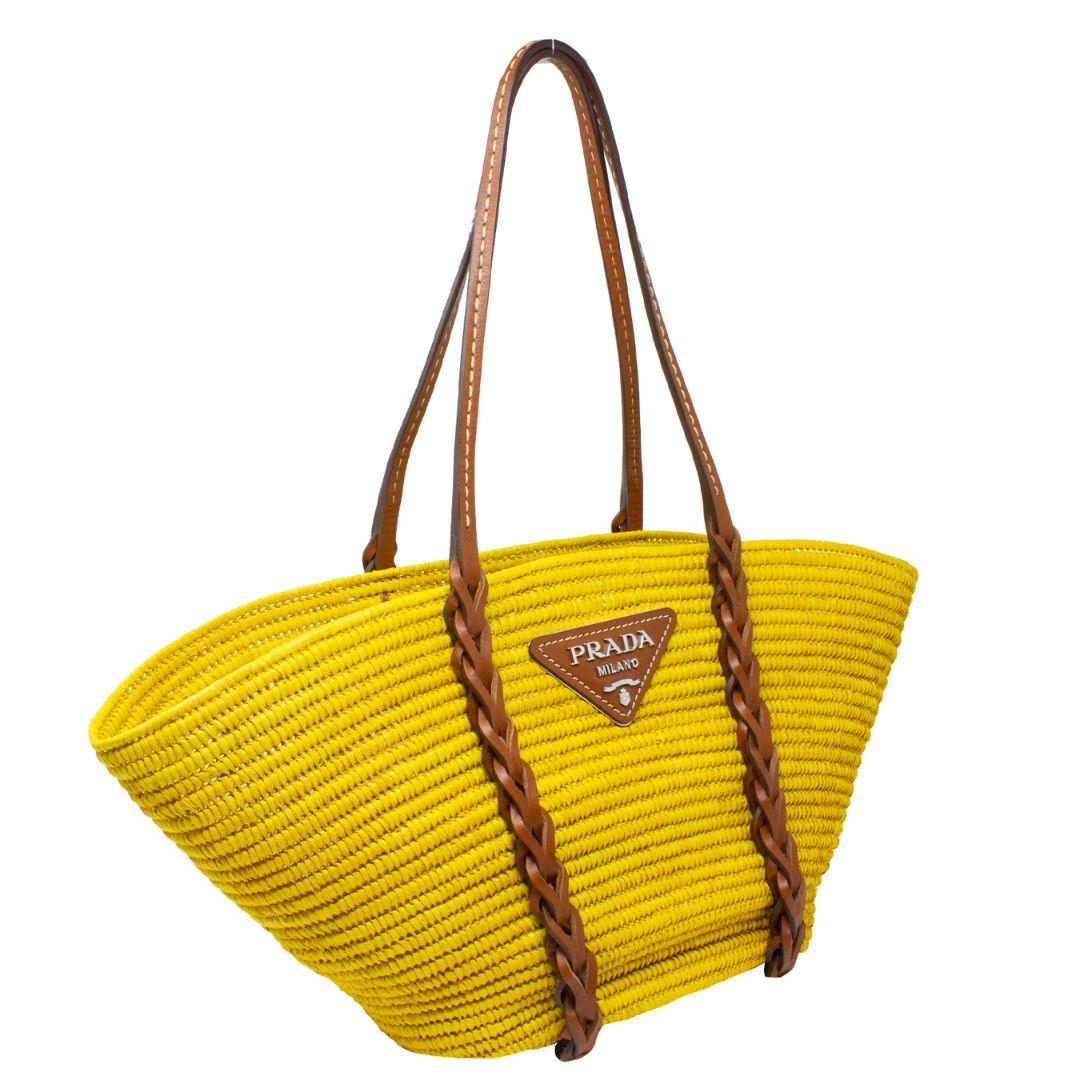The official bag of Spring/Summer is here and we are almost at a loss for words. This iconic tote is crafted in yellow basket weave straw, silver-tone hardware, with brown braided leather inserts that begin from the handles all the way down the bag,