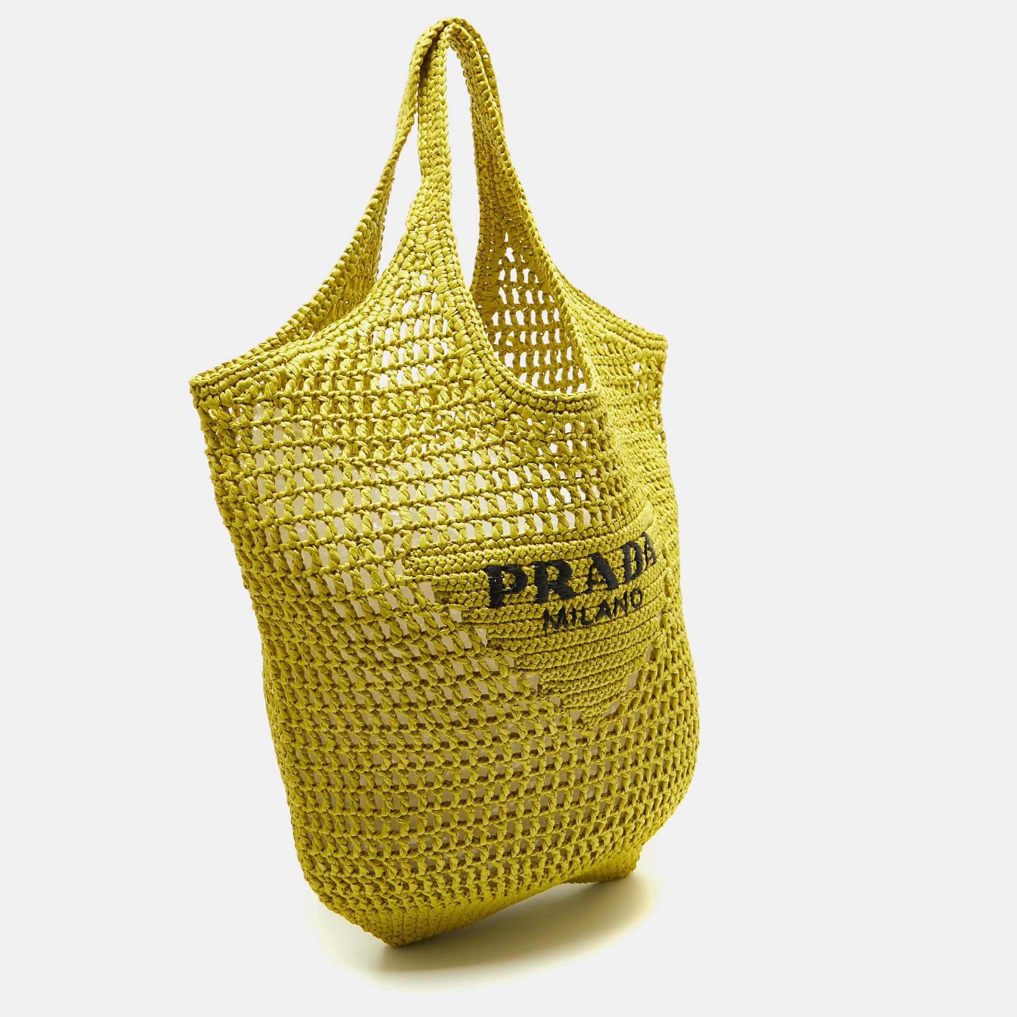 The Prada tote exudes effortless elegance with its sunny hue and intricate crochet detailing. Crafted from high-quality straw, it boasts a spacious interior perfect for carrying your essentials in style. This versatile accessory effortlessly