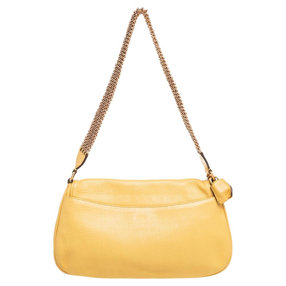 Coming to you in a lovely yellow shade, this Prada shoulder bag has a simple yet chic design. Made with leather, it features a twist-lock and gold-tone hardware, chain mail shoulder strap that gives it a modern spin. The perfect bag for a quick
