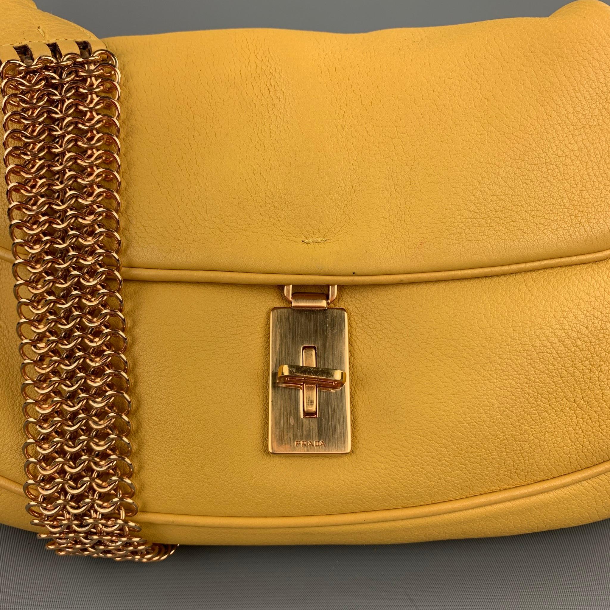 Le sac à main PRADA en cuir jaune est doté d'une sangle en chaîne de couleur dorée:: d'une poche intérieure et d'une fermeture à verrou tournant. Fabriqué en Italie. 

Très bon état d'origine. 
Marqué : 58

Mesures : 

Longueur : 9.5 pouces.