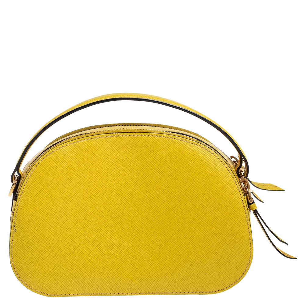 Designed in a structured silhouette, this Odette in yellow from Prada will make a pretty addition to your closet. It is crafted from Saffiano Lux leather with the brand label on the front, a top handle, and two zipper compartments lined with