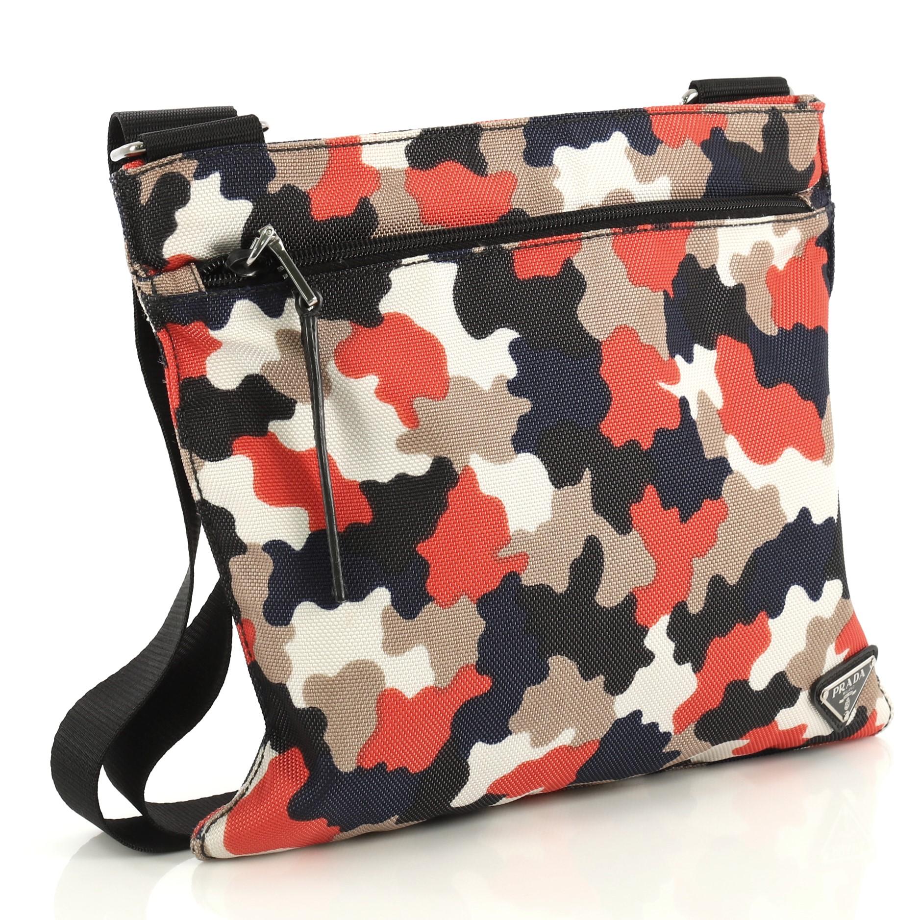 This Prada Zip Crossbody Bag Camouflage Canvas Medium, crafted in blue, orange and neutral canvas, features an adjustable strap, exterior front zip pocket, and silver-tone hardware. Its top zip closure opens to a black fabric interior. 

Condition: