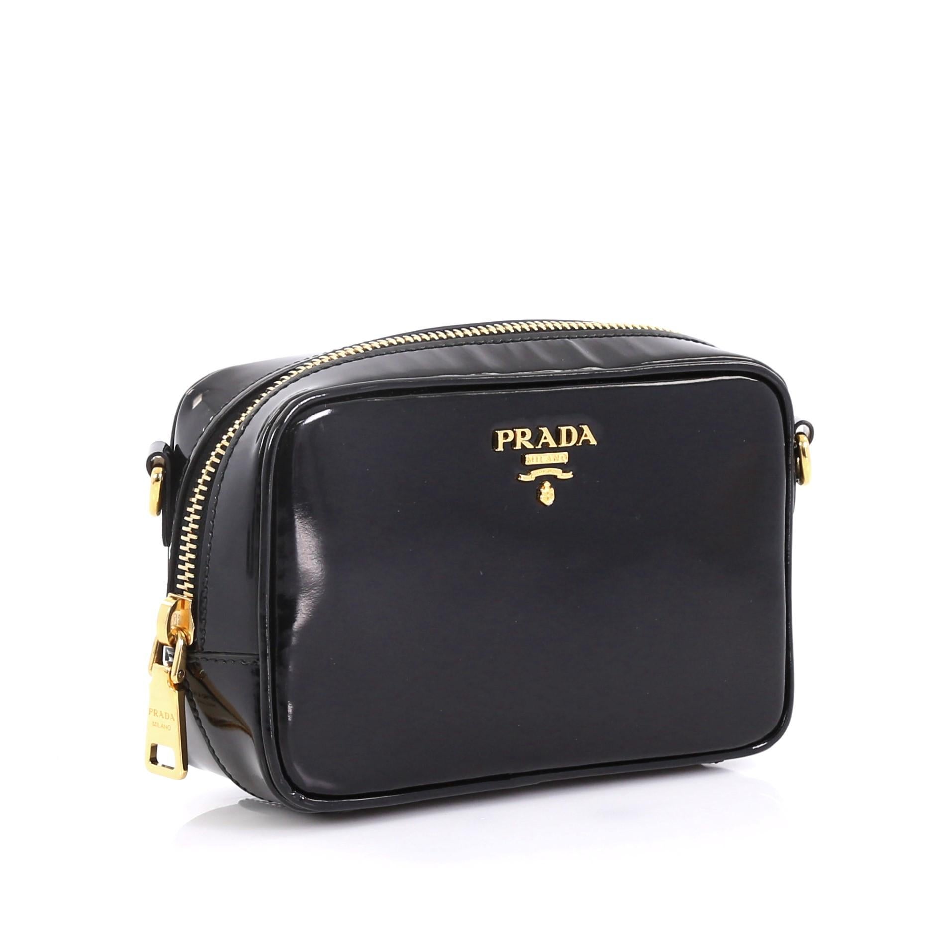 This Prada Zip Crossbody Bag Spazzolato Leather Mini, crafted in black spazzolato leather, features an adjustable leather strap, signature Prada logo, and gold-tone hardware. Its zip closure opens to a black fabric interior with slip pockets.