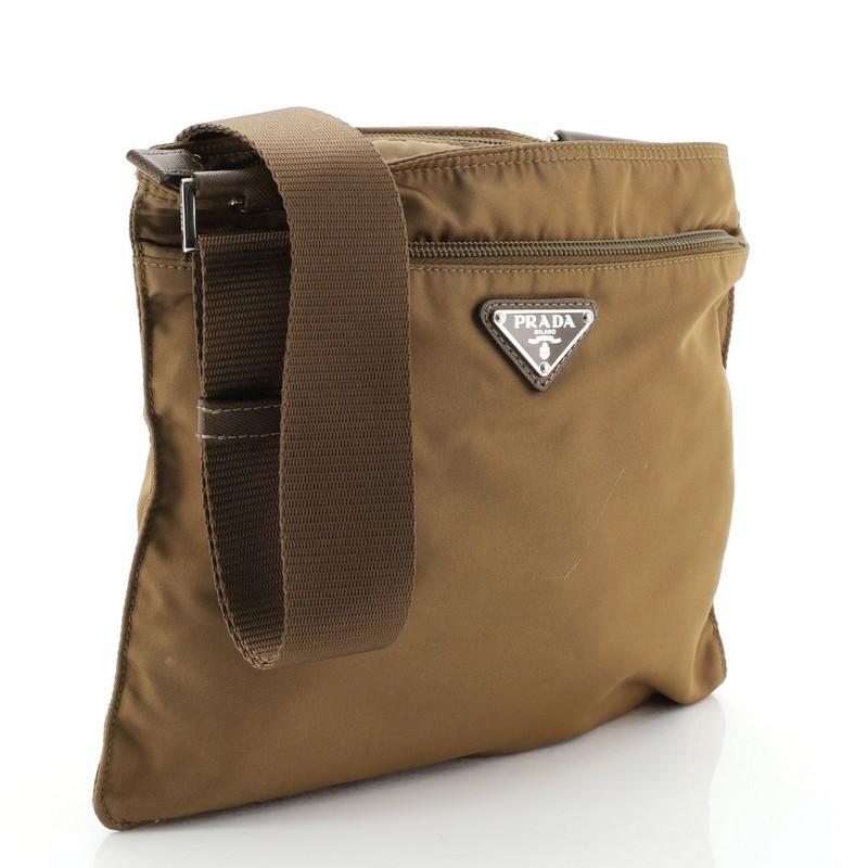 This Prada Zip Messenger Bag Tessuto Medium, crafted from brown tessuto, features an adjustable shoulder strap and silver-tone hardware. Its zip closure opens to a brown nylon and fabric interior. 

Condition: Fair. Marks, scuffs and wear on