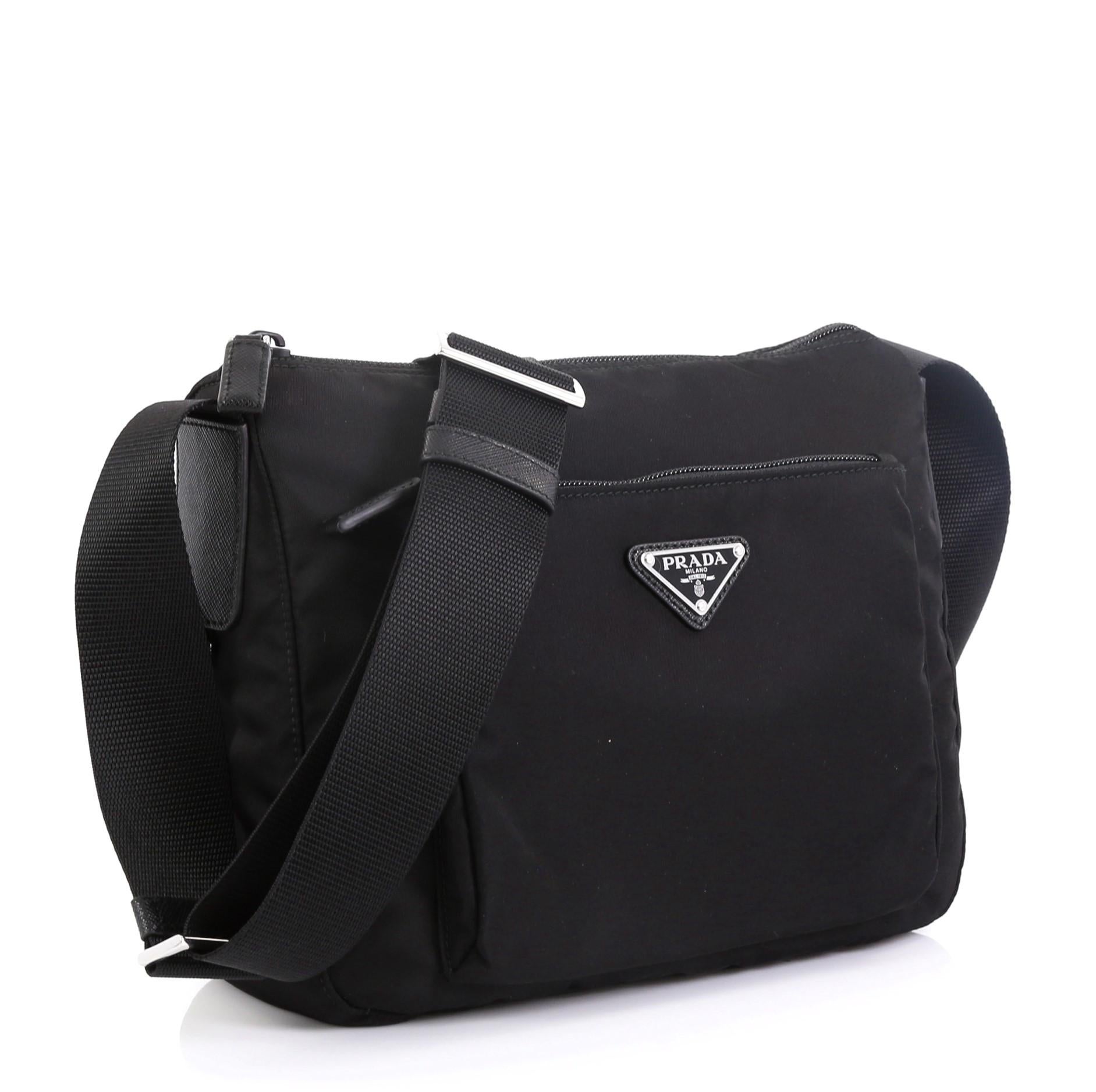 This Prada Zip Messenger Bag Tessuto Small, crafted from black tessuto, features adjustable shoulder strap, exterior zip pocket, and silver-tone hardware. Its top zip closure opens to a black fabric interior. 

Condition: Excellent. Faint wear on